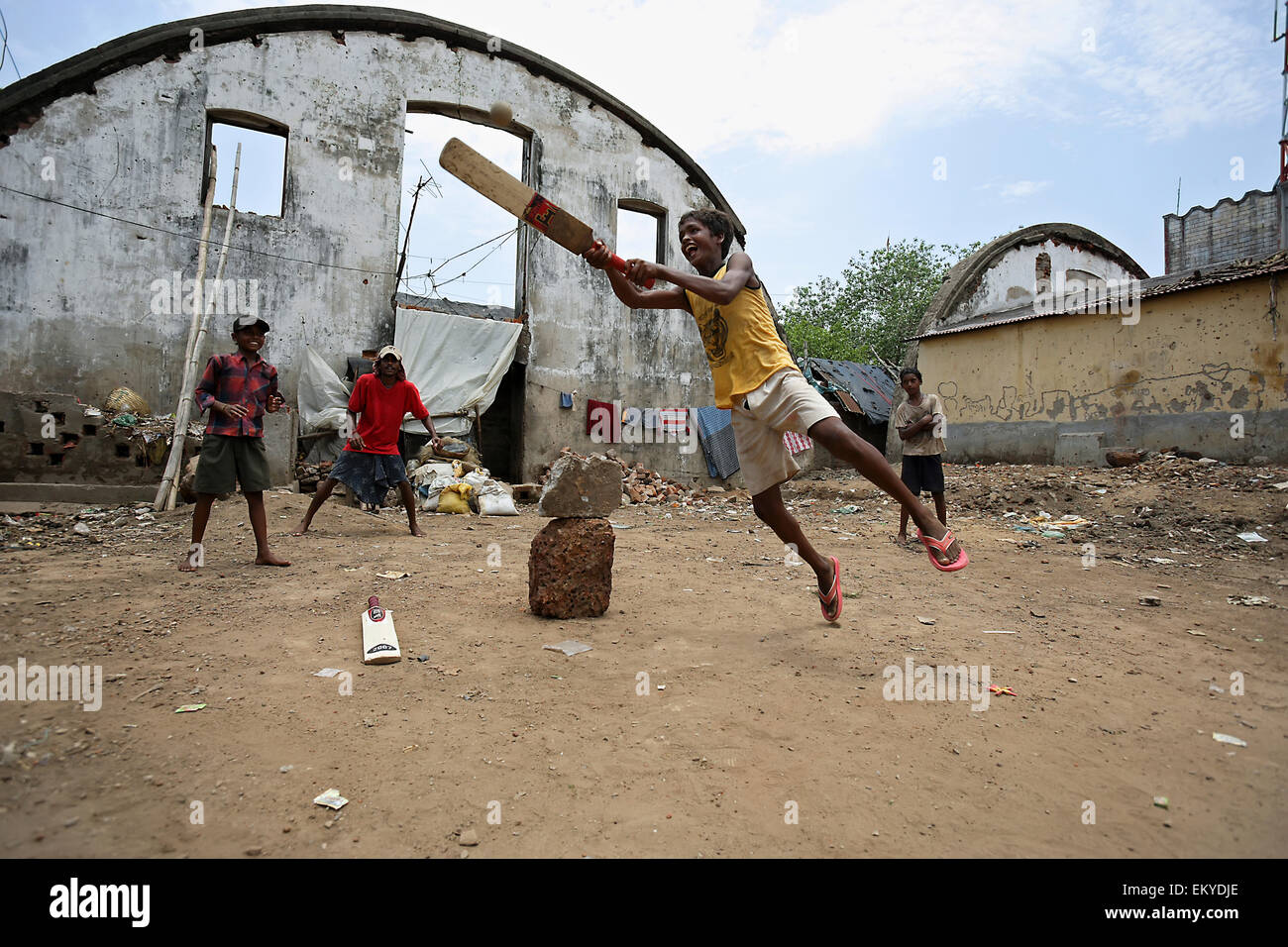 Group of boys play cricket close to their homes; Cuttack, Odisha, India Stock Photo