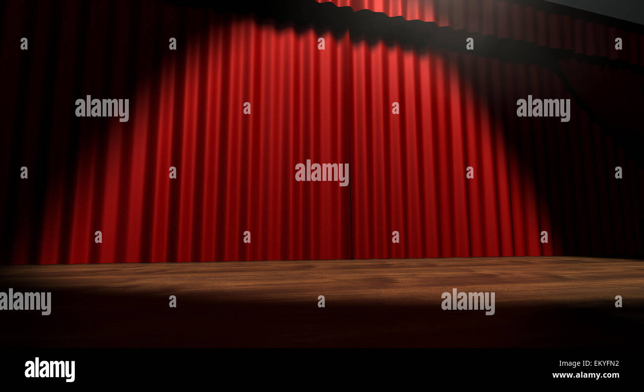 A regular theater stage with closed red curtains lit by a single spotlight Stock Photo