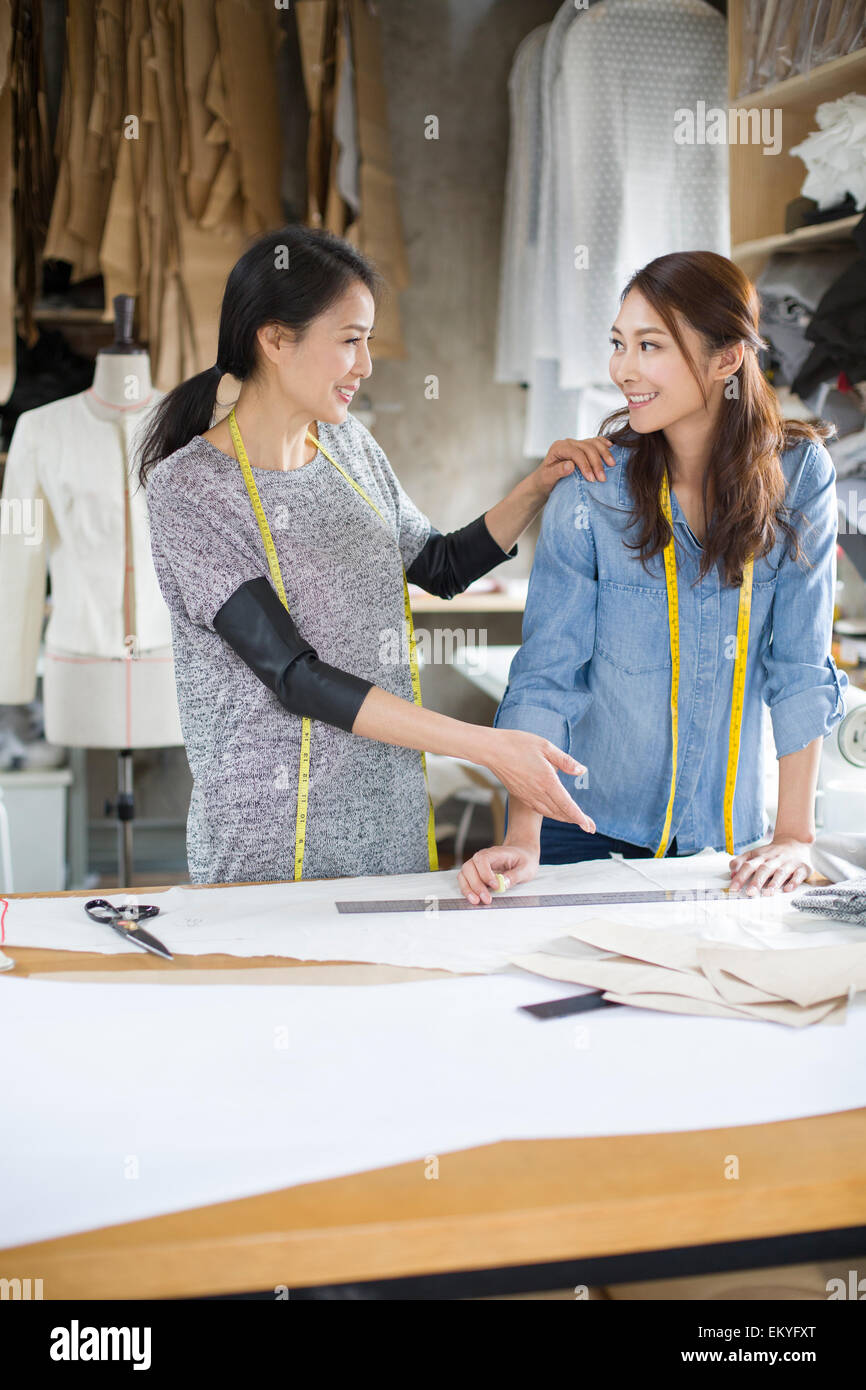 Two female fashion designers talking in studio Stock Photo - Alamy