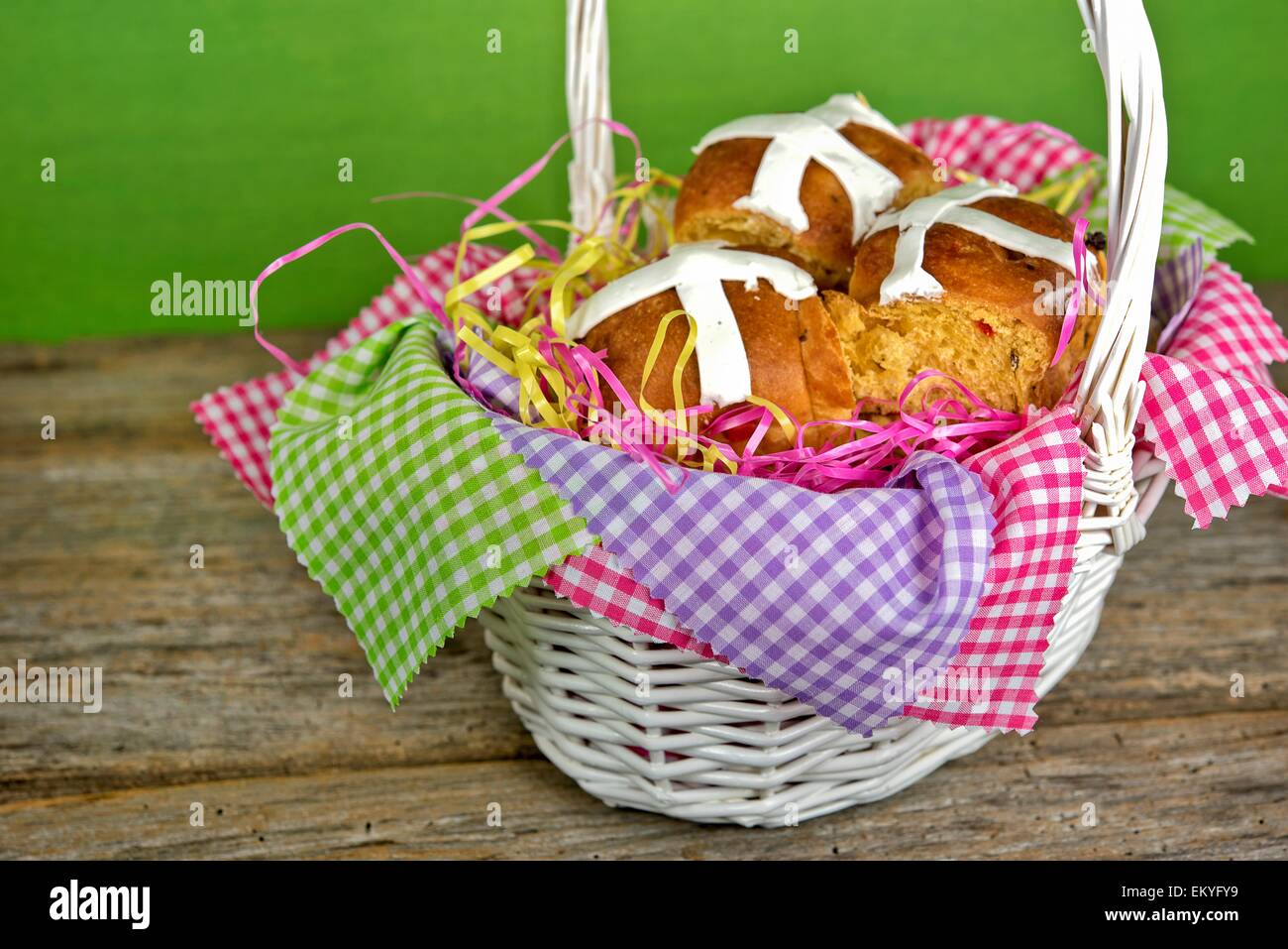 Easter hot cross buns in white wicker basket with gingham fabric. Stock Photo