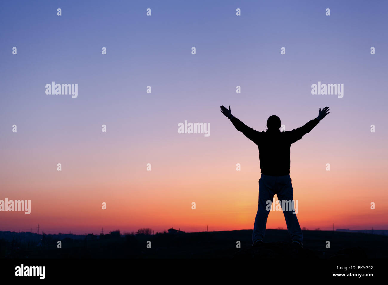 Silhouette of man with arms raised up and beautiful sky. Element of design. Summer sunset. Background Stock Photo