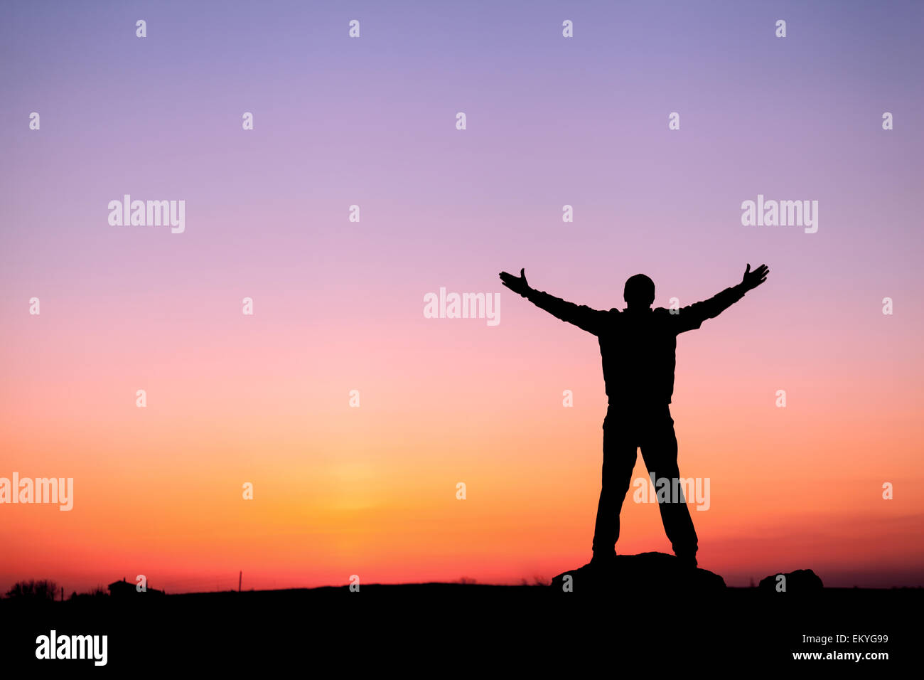 Silhouette of man with arms raised up and beautiful sky. Element of design. Summer sunset. Background Stock Photo