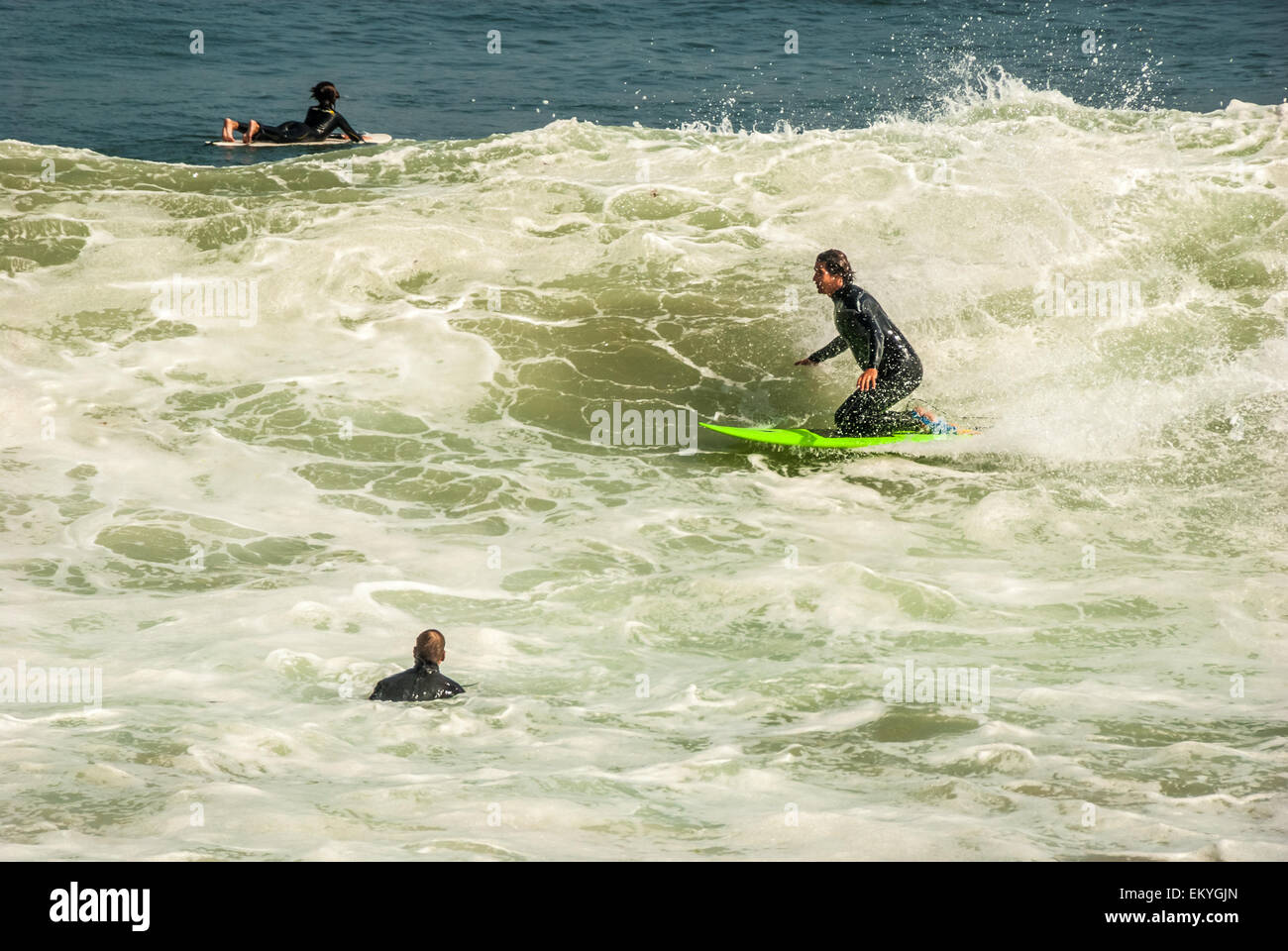 Kneeboarding surfer shoots across a large, overhead shorebreak wave at Malibu Beach, California. USA. Stock Photo