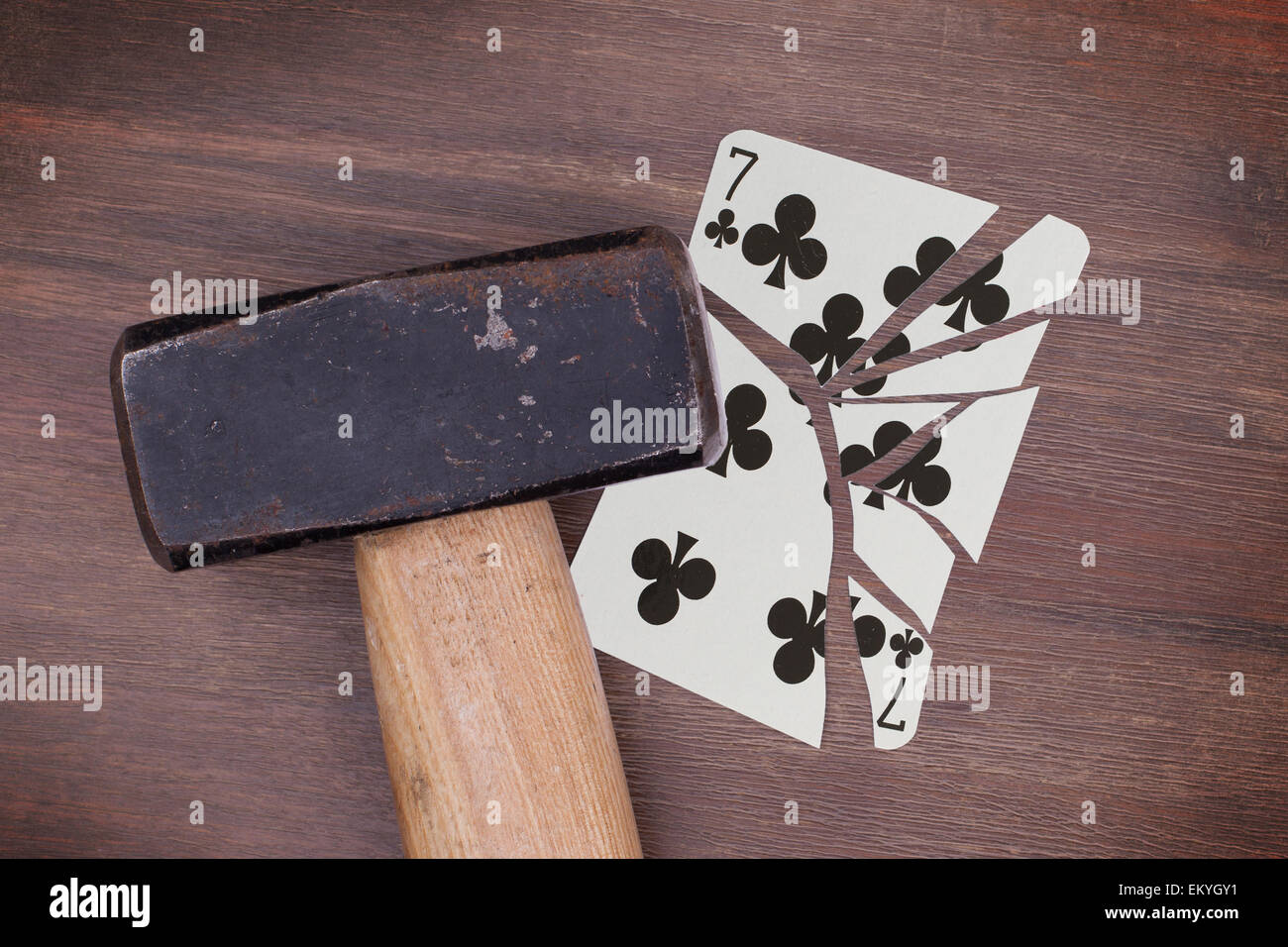 Hammer with a broken card, vintage look, seven of clubs Stock Photo