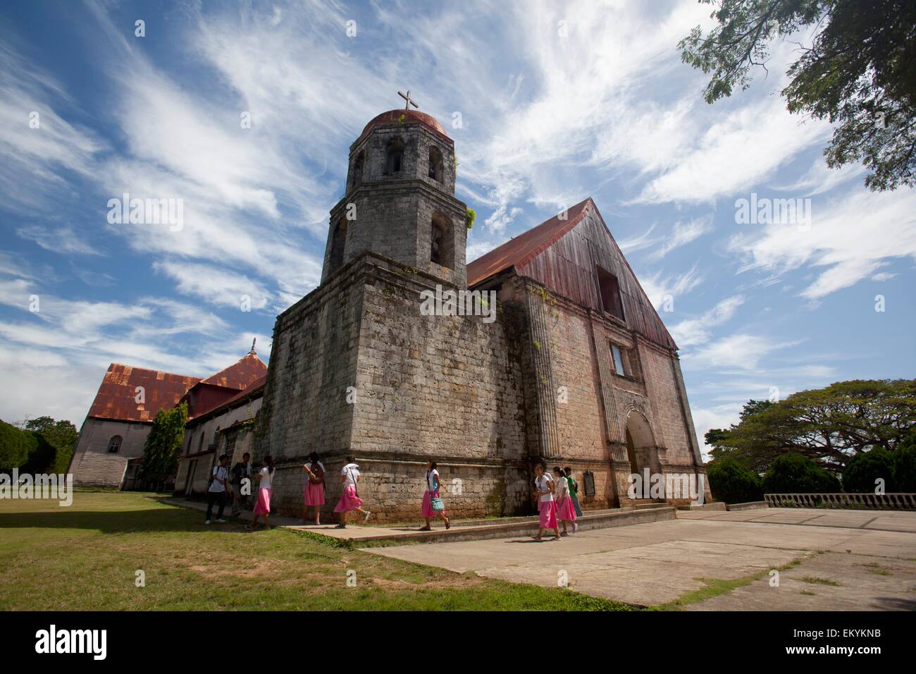 Schoolchildren Walk Past The Historic San Antonio De Padua Church; Lazi, Siquijor, Philippines Stock Photo