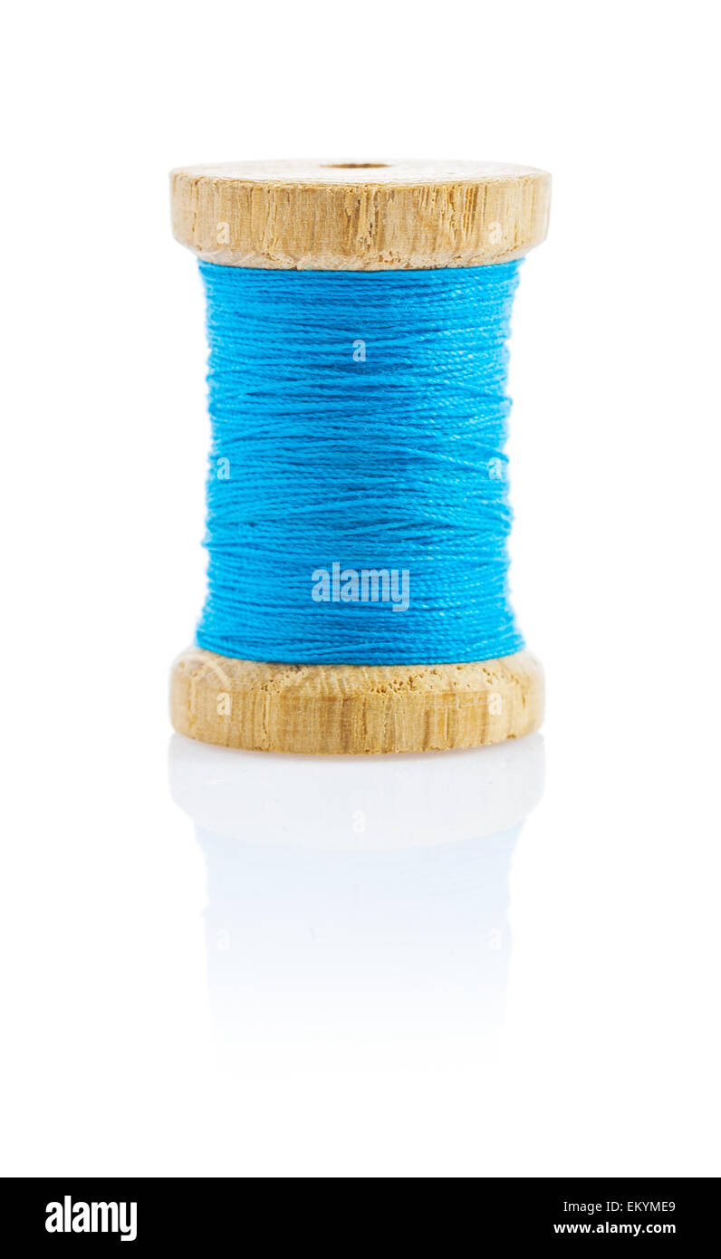 a small wooden bobbin with blue thread Stock Photo