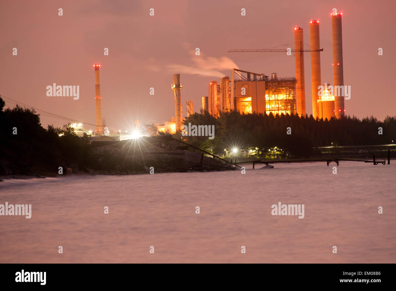 A smoking industrial power plant on seaside at night Stock Photo