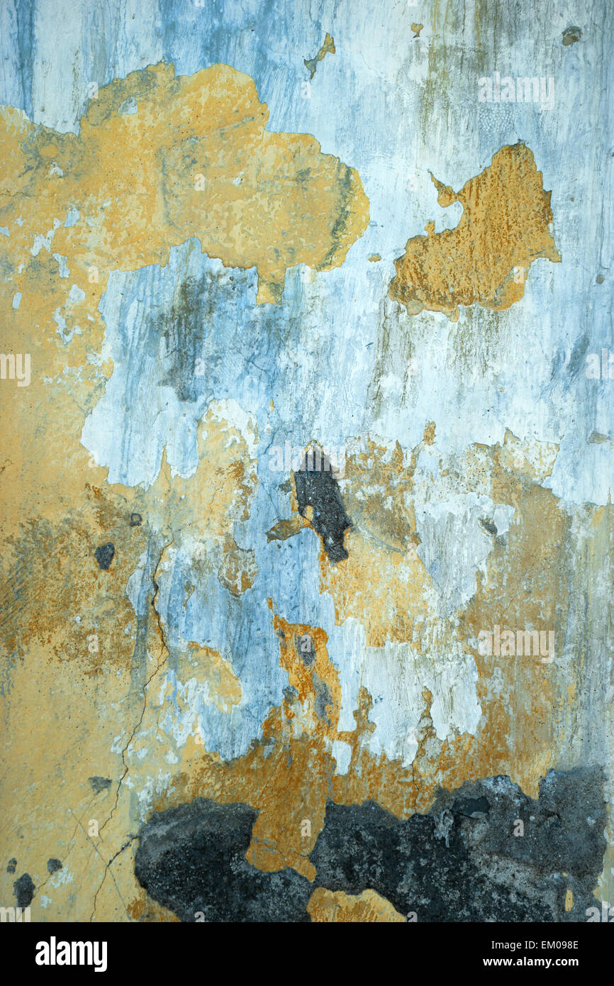 peeling wall paint - old cement  wall overpainted many times, different colors showing Stock Photo
