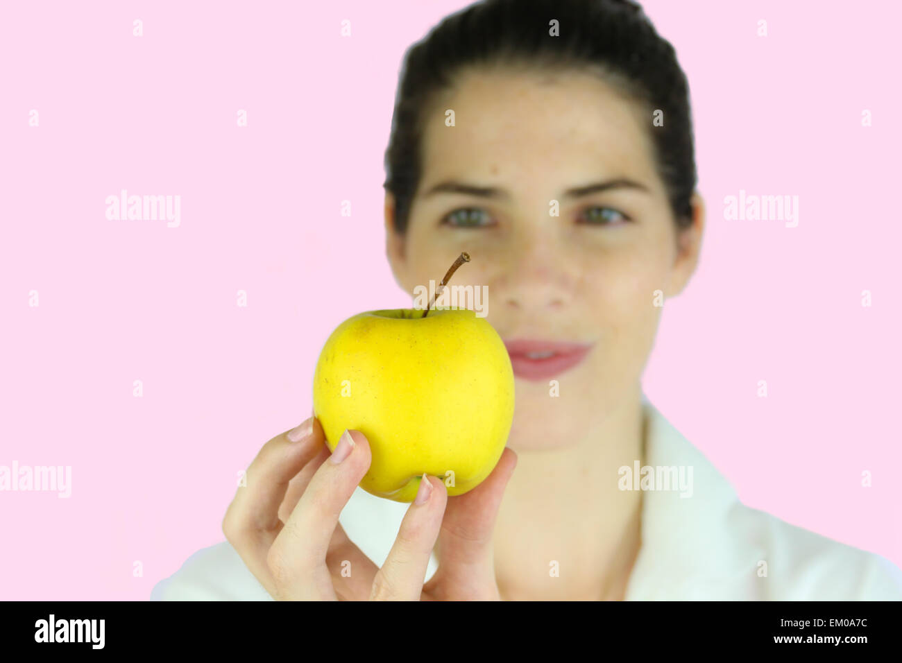 Girl holding a yellow apple Stock Photo
