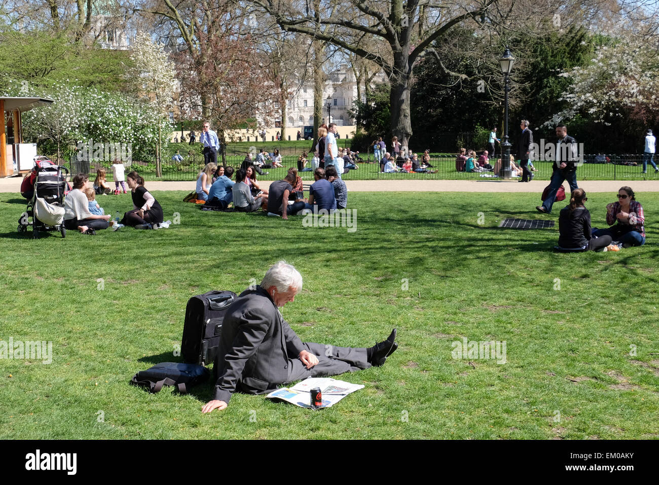 London, UK. 14th April, 2015. Man in suit reads newspaper in St.James's Park. Londoners and tourists enjoy the parks and public spaces as temperatures rise in Spring. Credit:  Eden Breitz/Alamy Live News Stock Photo