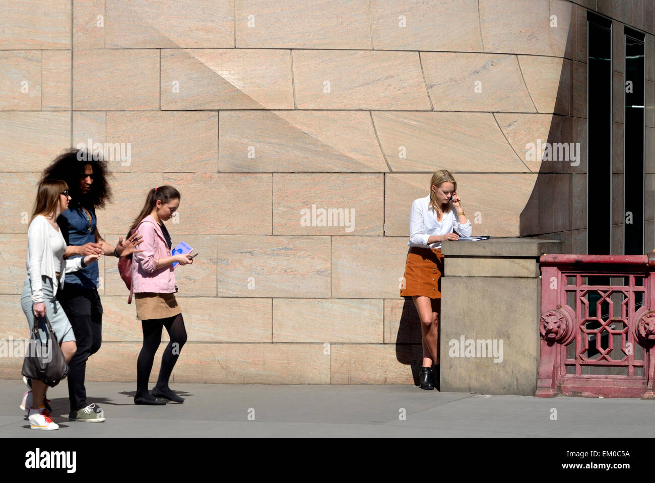 London, England, UK. Young woman in a skirt talking on her mobile phone, Holborn Viaduct Stock Photo