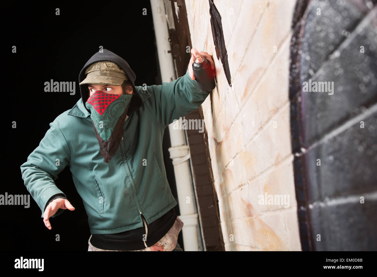 Worried Gang Member Spray Painting Stock Photo