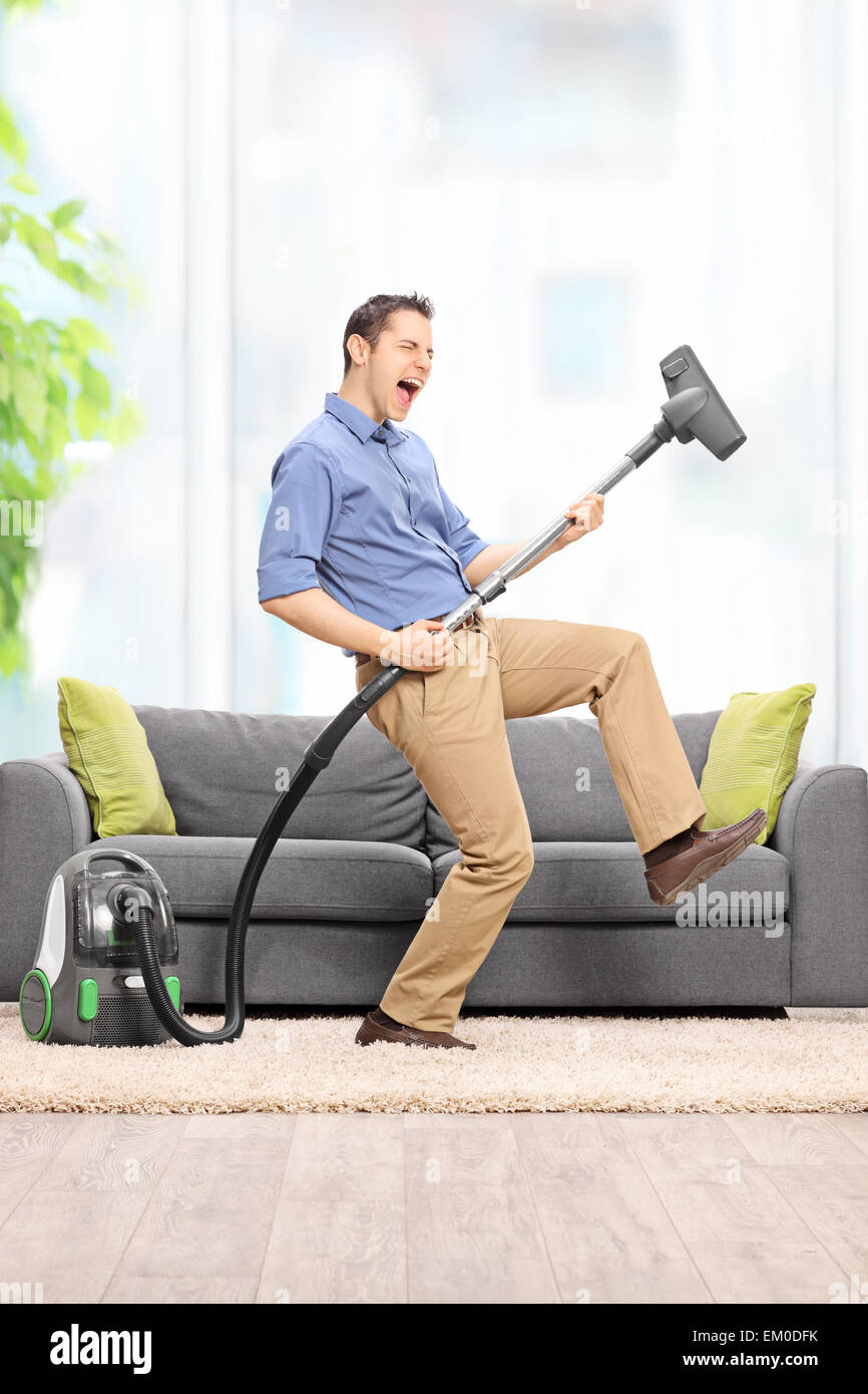 https://c8.alamy.com/comp/EM0DFK/delighted-young-guy-playing-guitar-on-the-vacuum-cleaner-wand-in-front-EM0DFK.jpg