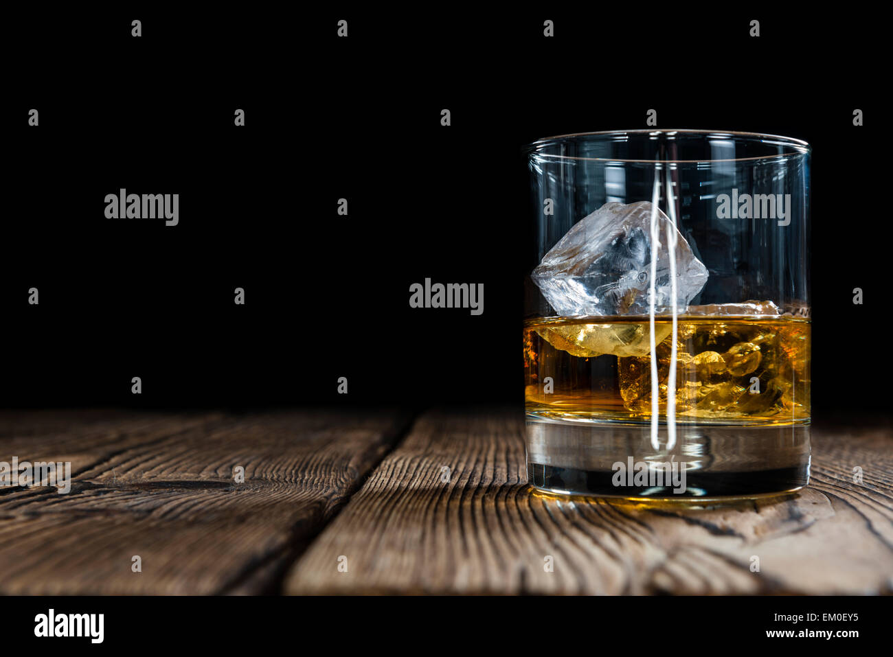 Single Malt Whiskey with Ice Cubes on wooden background Stock Photo