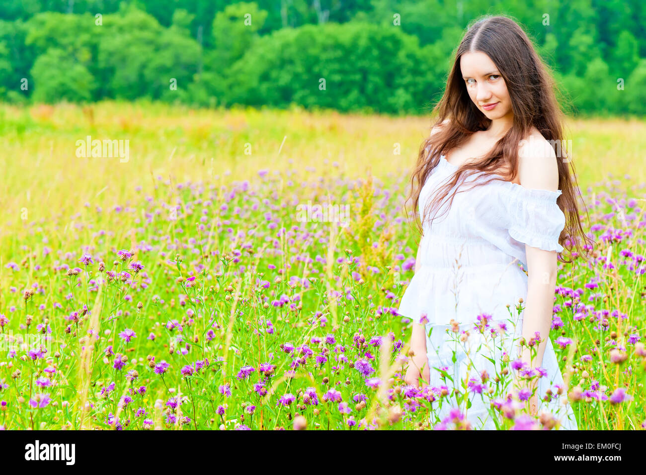 beautiful girl standing in a field Stock Photo - Alamy