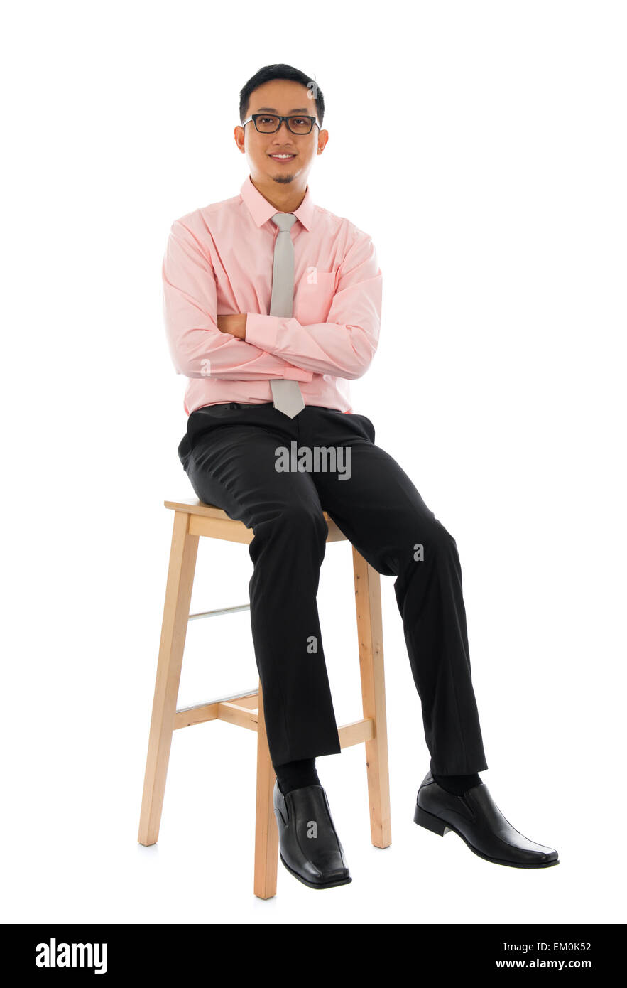 Asian businessman sitting on a wooden chair Stock Photo - Alamy