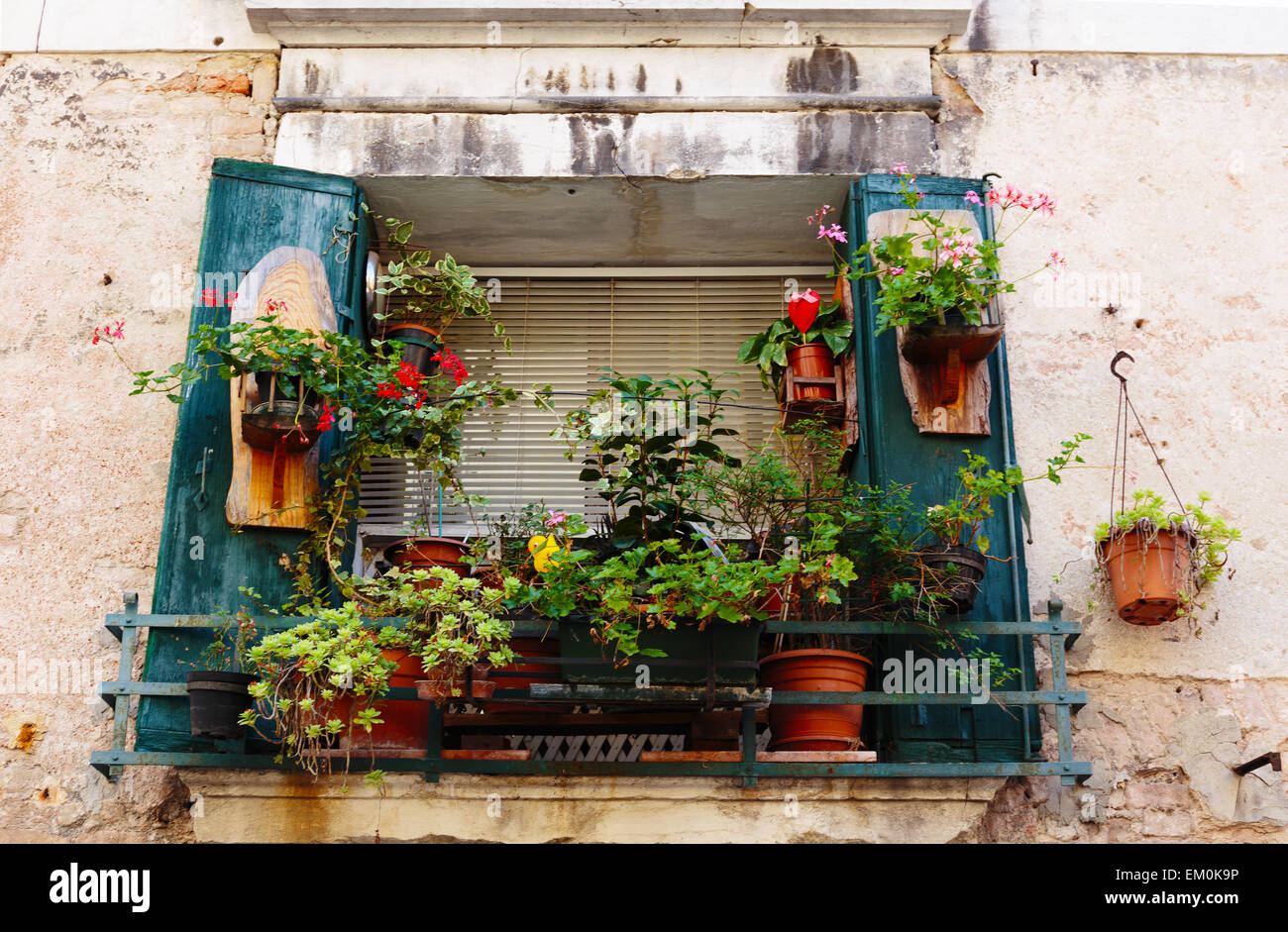 Window in an old house decorated with flower pots and flowers Stock Photo