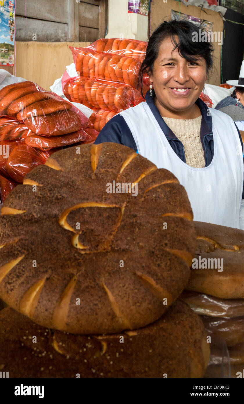 Peru, Cusco, San Pedro Market.  Woman Offering Bread for Sale. Stock Photo
