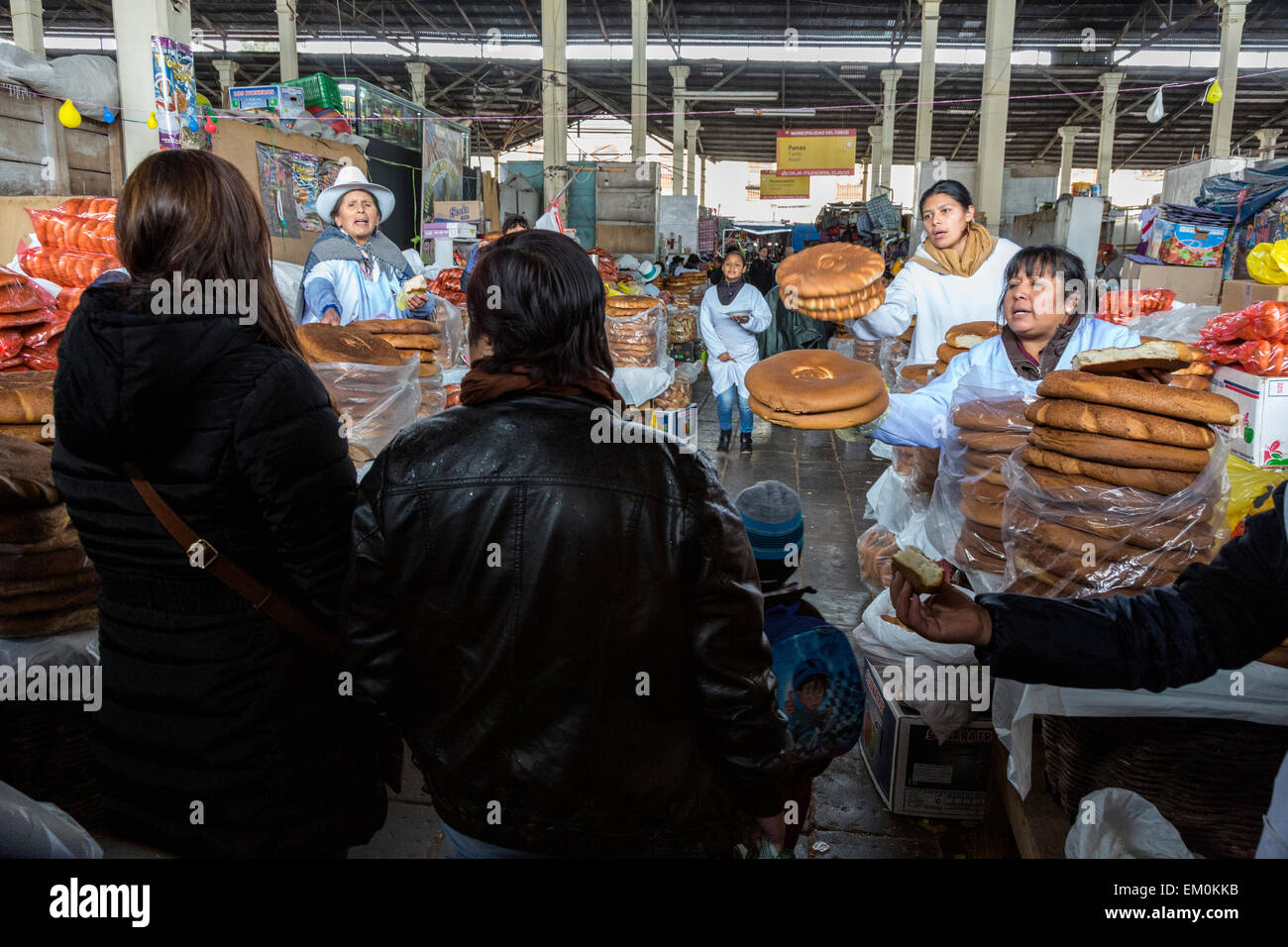 Peru, Cusco, San Pedro Market.  Women Selling Bread Clamoring for Attention of Potential Buyers. Stock Photo