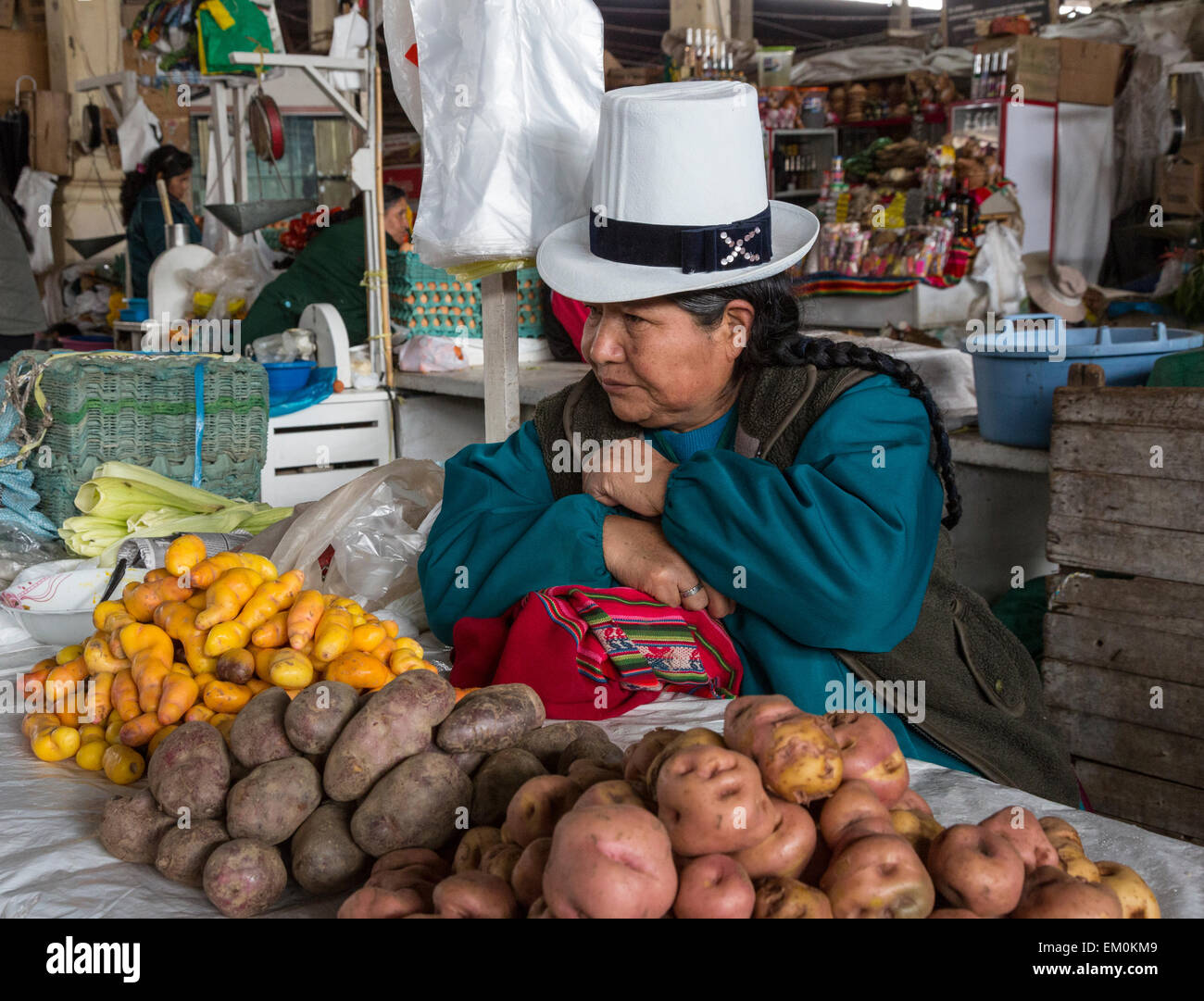 Peru, Cusco.  Peruvian Woman Selling Two  Varieties of Potatoes, plus Olluco (far left, orange-colored), an Andean vegetable. Stock Photo