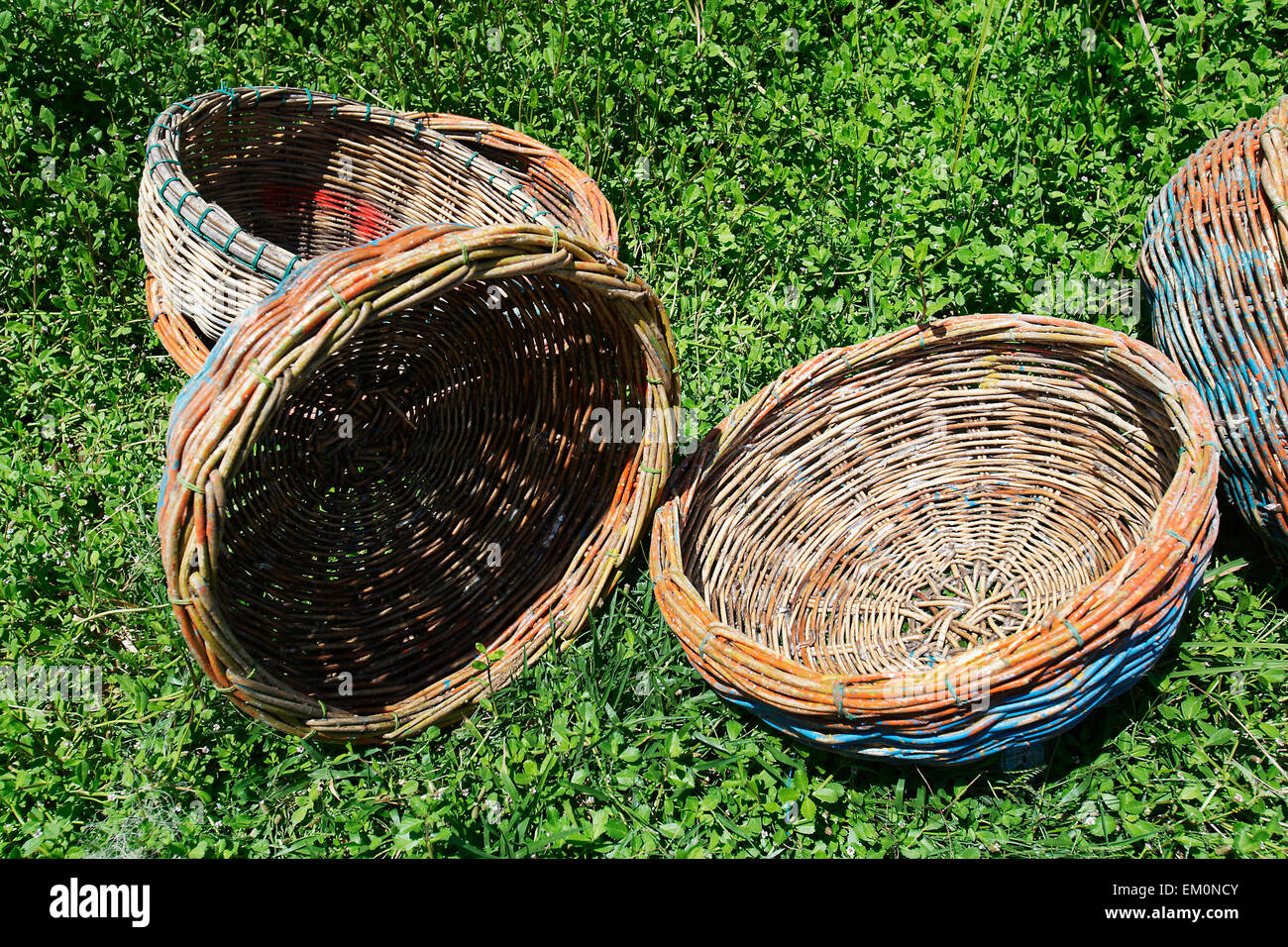 Baskets used by fishermen lay out to dry on the grass; Lamno, Aceh Province, Sumatra, Indonesia Stock Photo