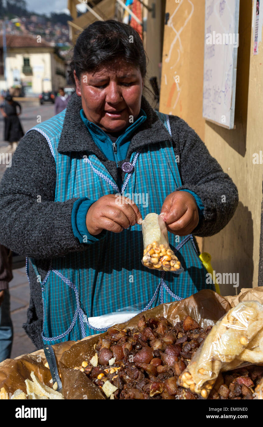 Peru, Cusco.  Woman Selling Fried Pork Rind Snacks on the Street. Stock Photo