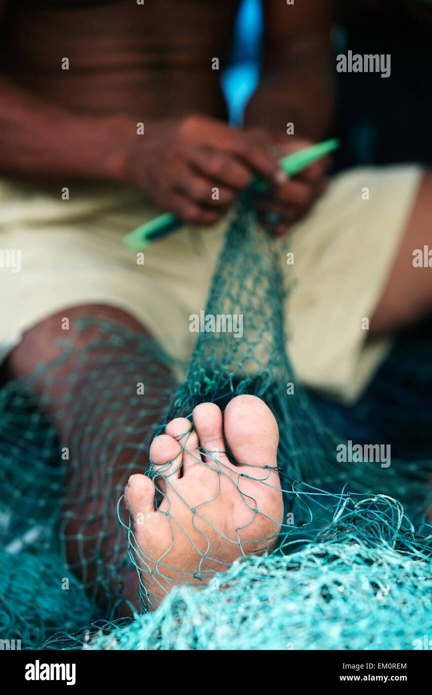 A fisherman repairs a net in Lhok Seudu village; Aceh Province, Sumatra, Indonesia Stock Photo