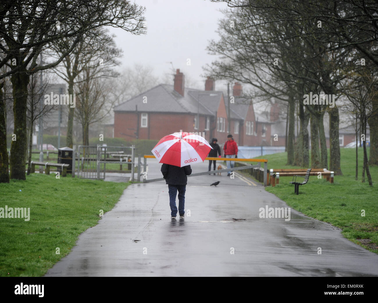 As the south of England basks in Mediterranean temperatures, it was dull and drizzly for these dog walkers  in Bolton Stock Photo