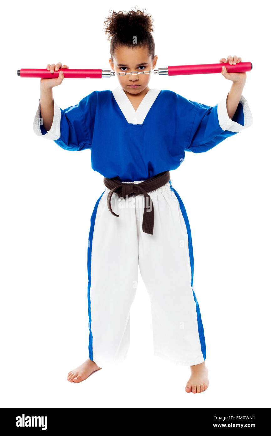 Young girl in karate uniform holding nunchucks Stock Photo Alamy
