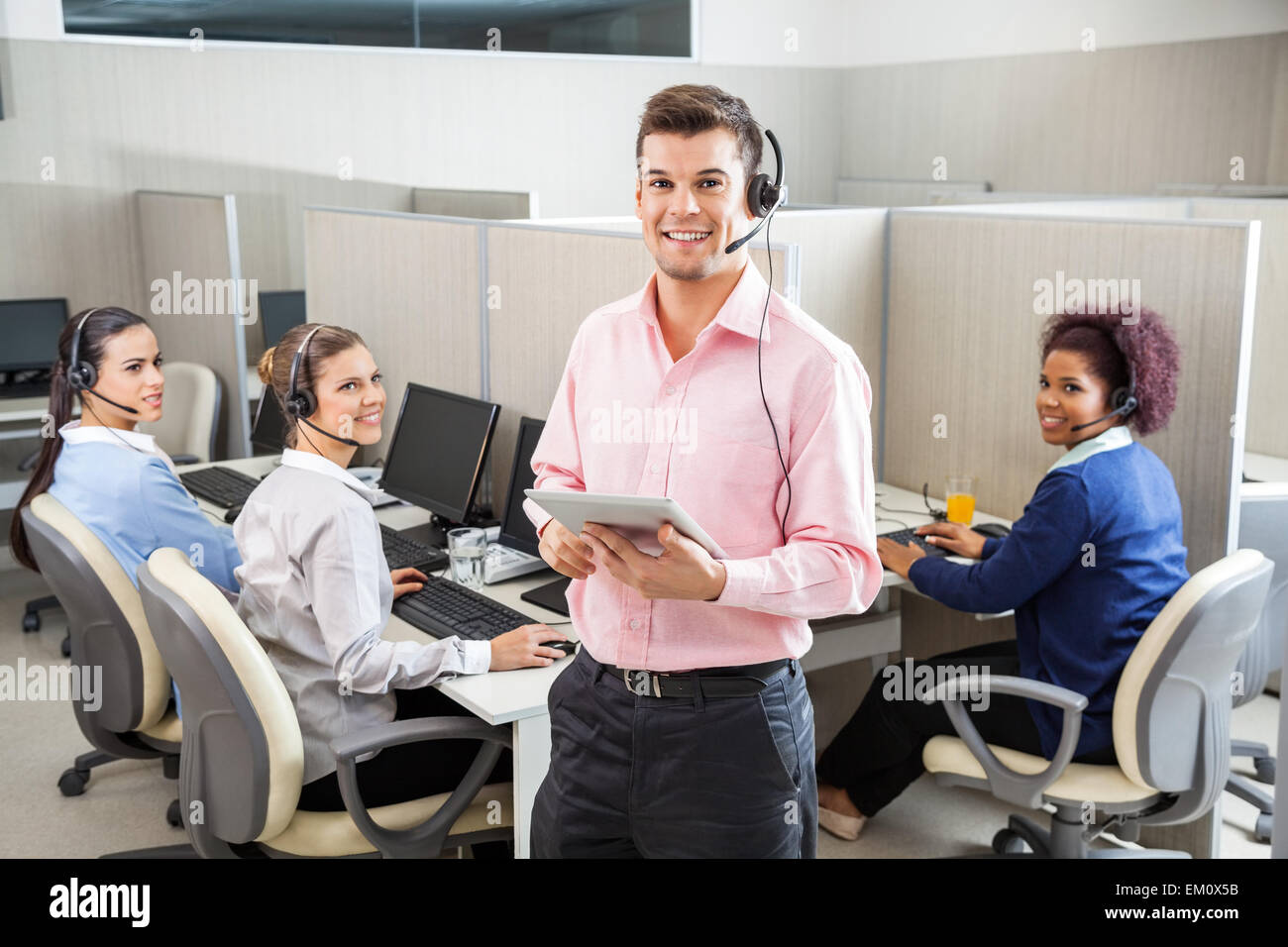 Customer Service Executive Holding Tablet Computer In Call Cente Stock Photo