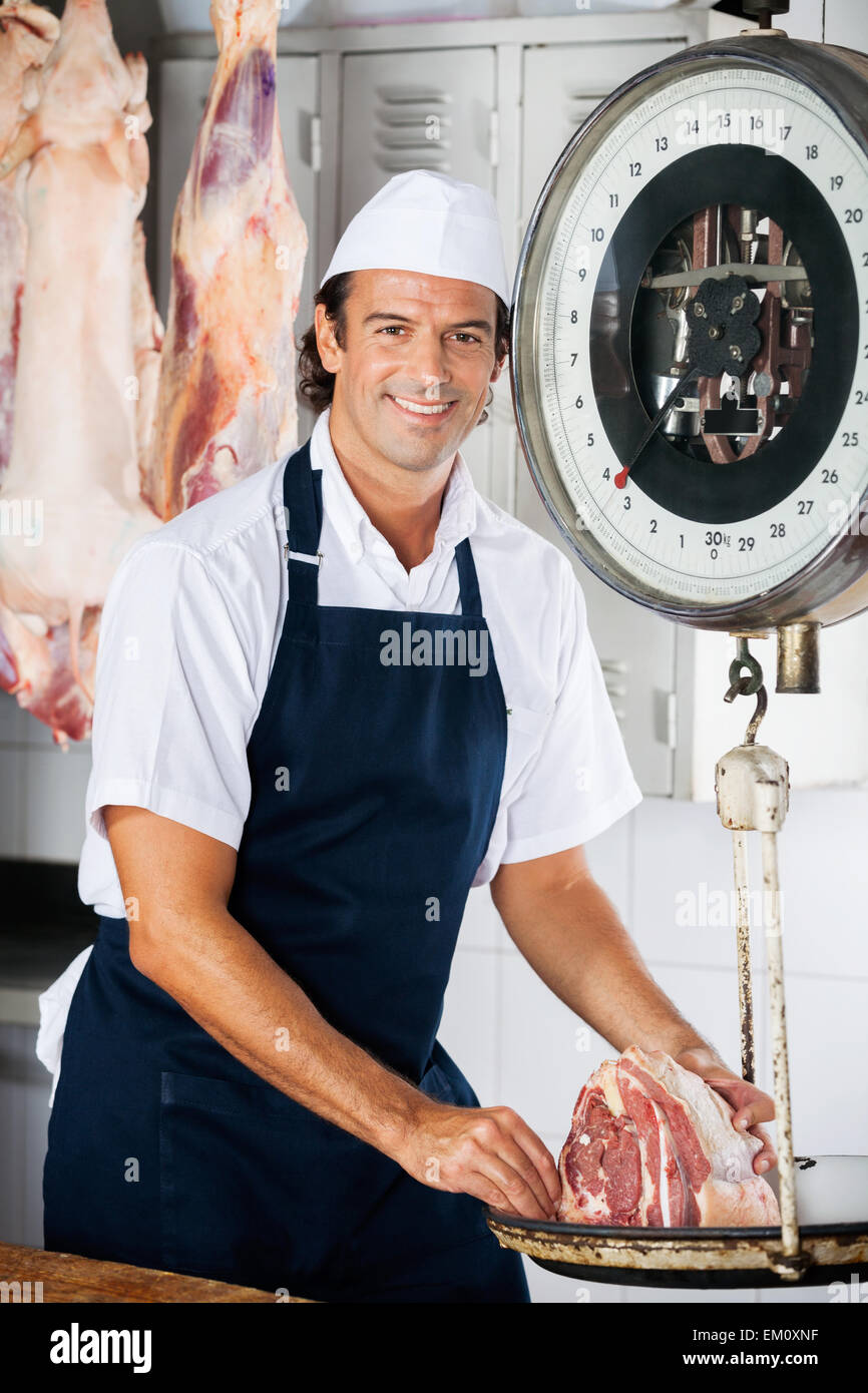 https://c8.alamy.com/comp/EM0XNF/confident-butcher-weighing-meat-on-machine-EM0XNF.jpg