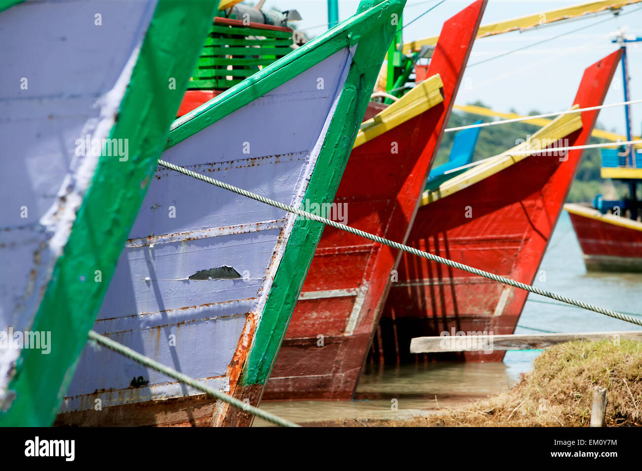 Colourful hulls of fishing boats in a row in the water; Aceh Province, Sumatra, Indonesia Stock Photo