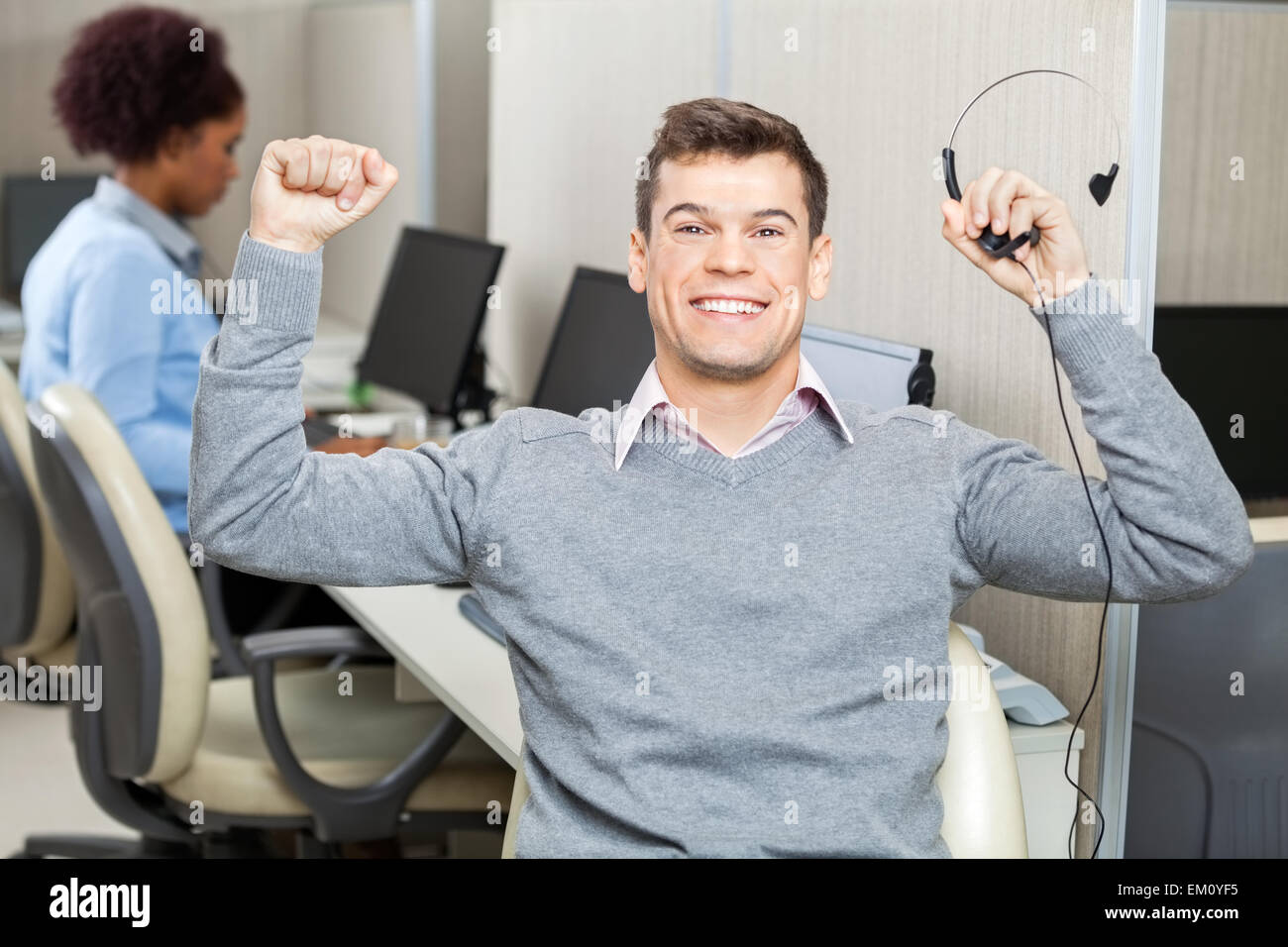Customer Service Representative With Arms Raised Holding Headset Stock