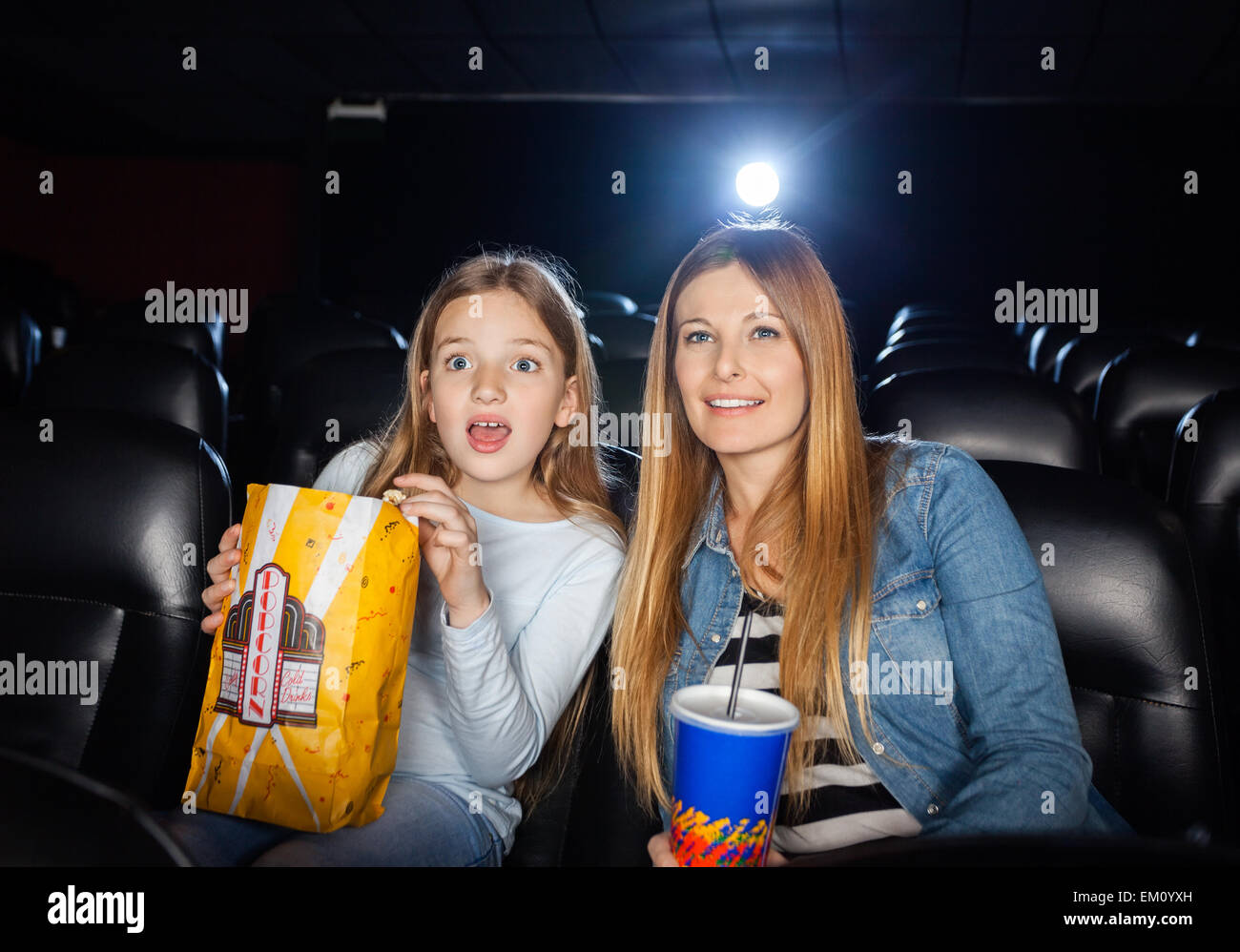 Surprised Mother And Daughter Watching Film Stock Photo