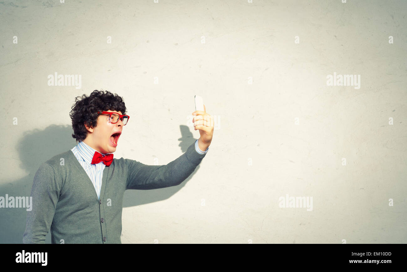Young man shouting at his mobile phone Stock Photo