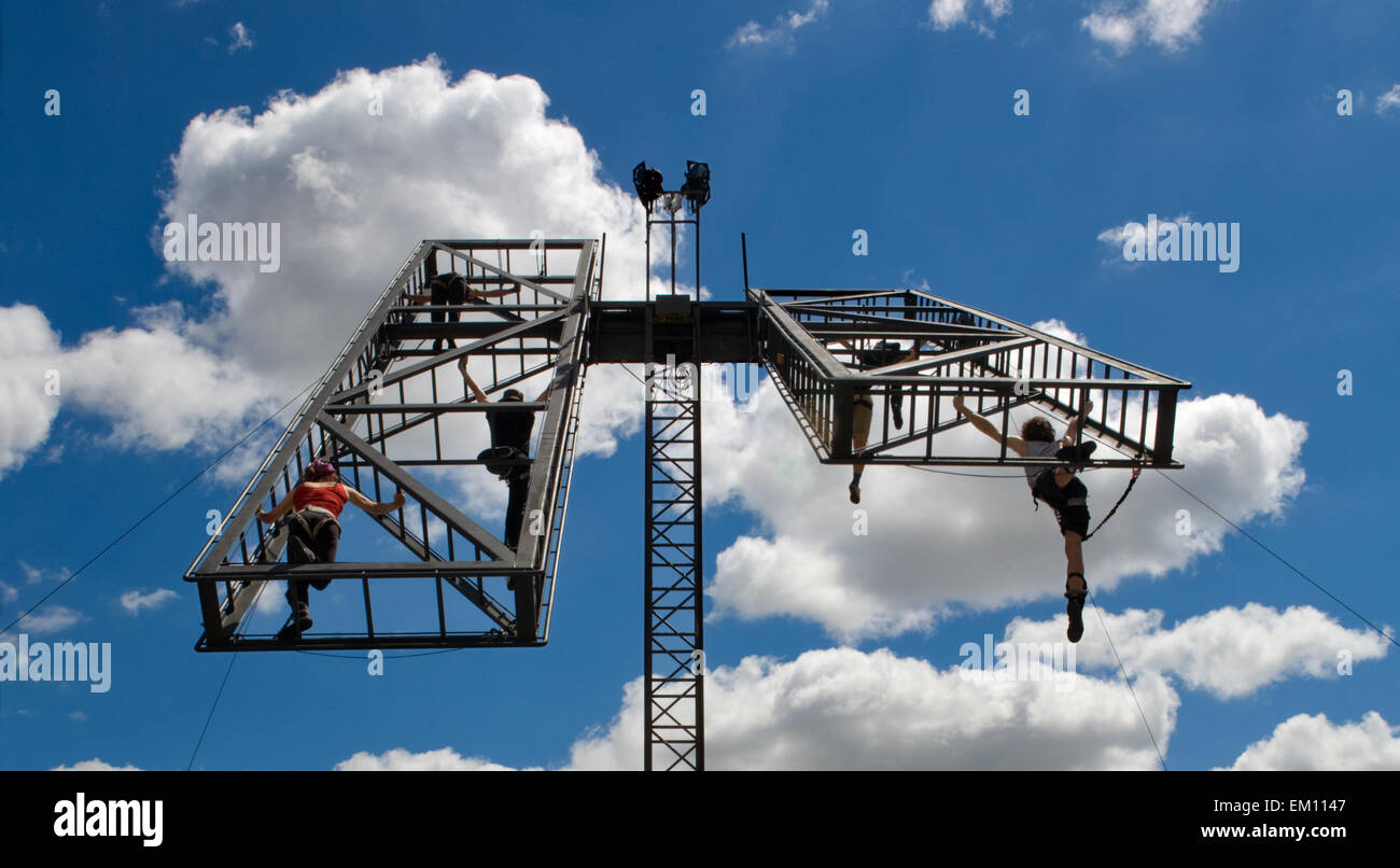 Dancers performs aerial acrobatic show with a metallic platfform on sky Stock Photo