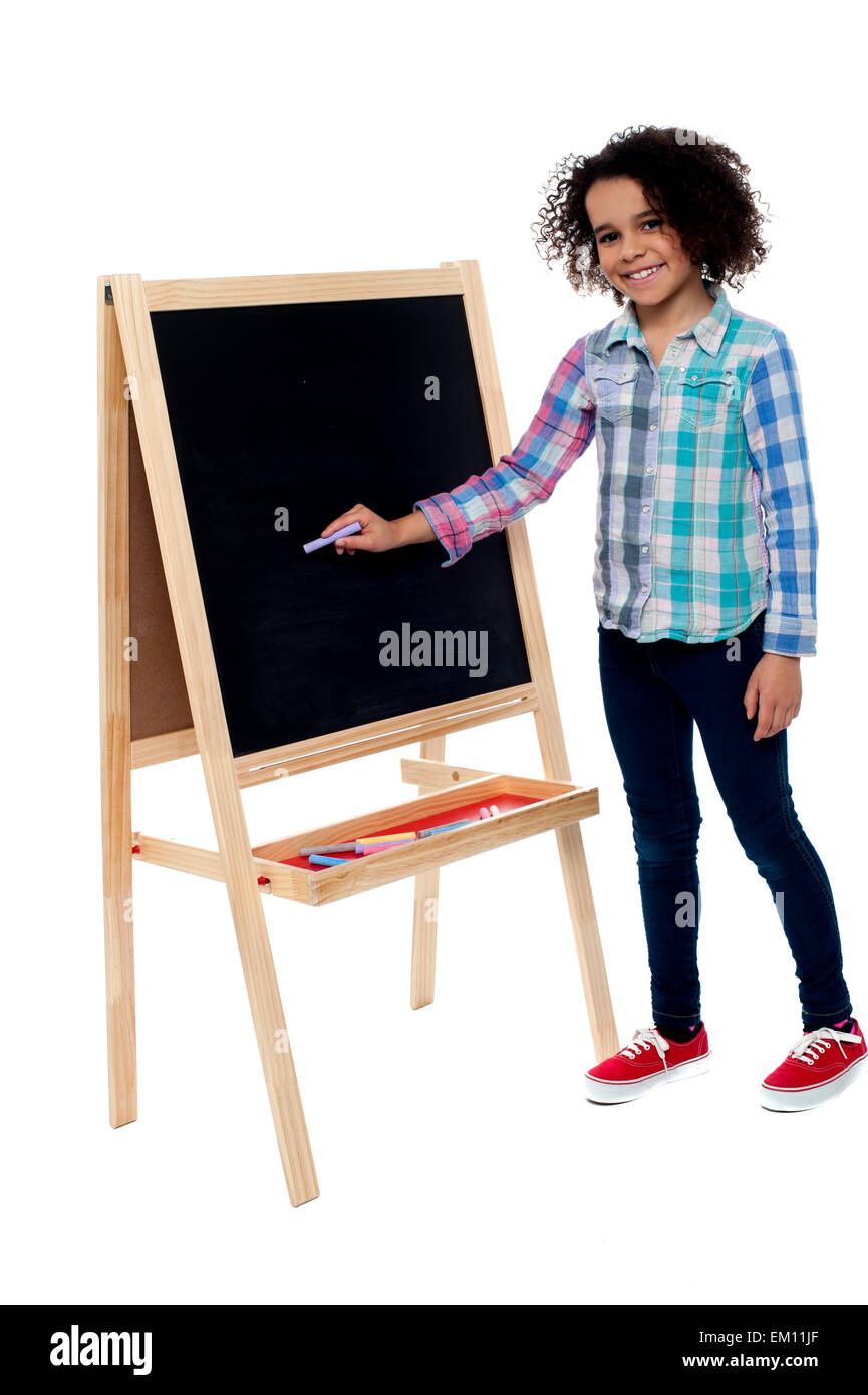 Charming young girl writing on blackboard Stock Photo - Alamy