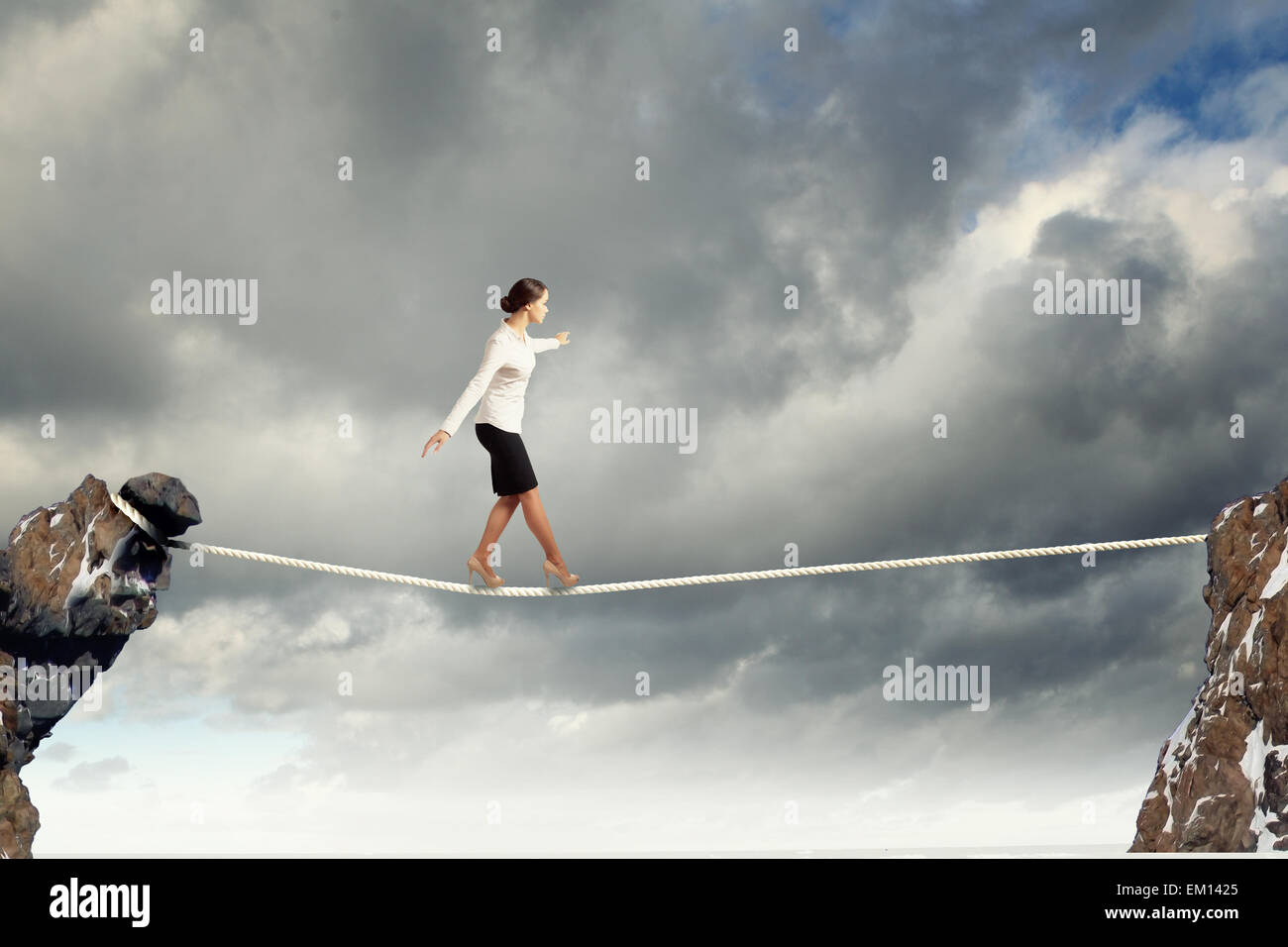 Businesswoman balancing on rope Stock Photo - Alamy