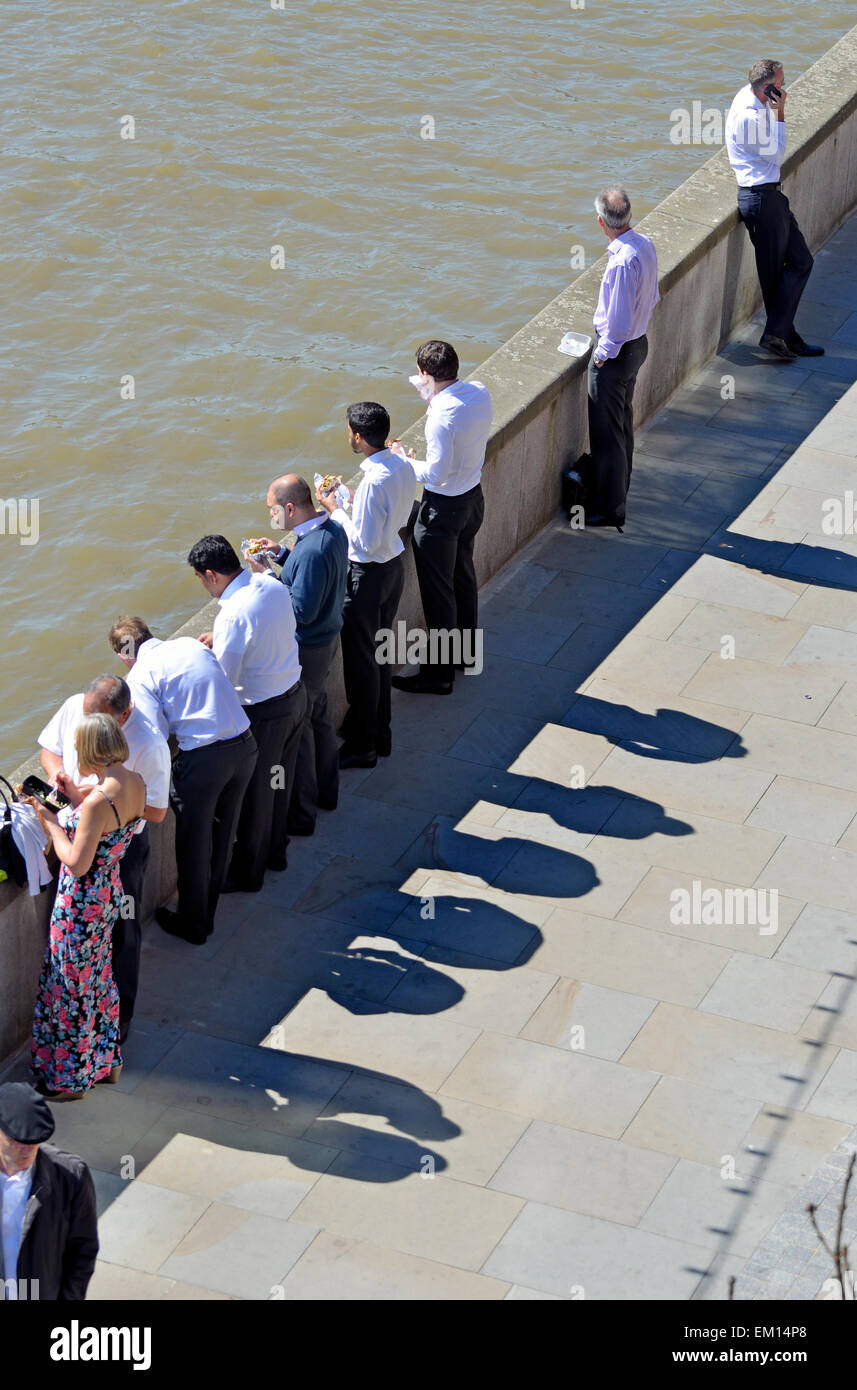 London, England, UK. City workers eating lunch outside by the River Thames on the warmest day of the year so far (14/04/2015) Stock Photo