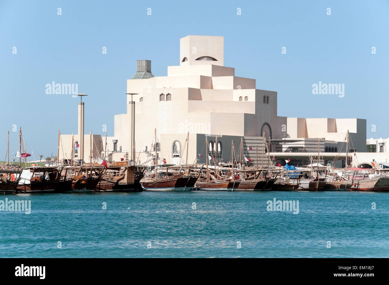 Traditional wooden dhow boats moored at a wharf in front of the Museum of Islamic Art in Doha, Qatar. Stock Photo