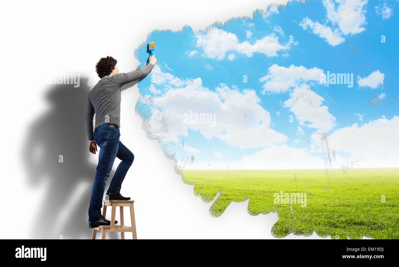 Young man drawing a cloudy blue sky Stock Photo - Alamy