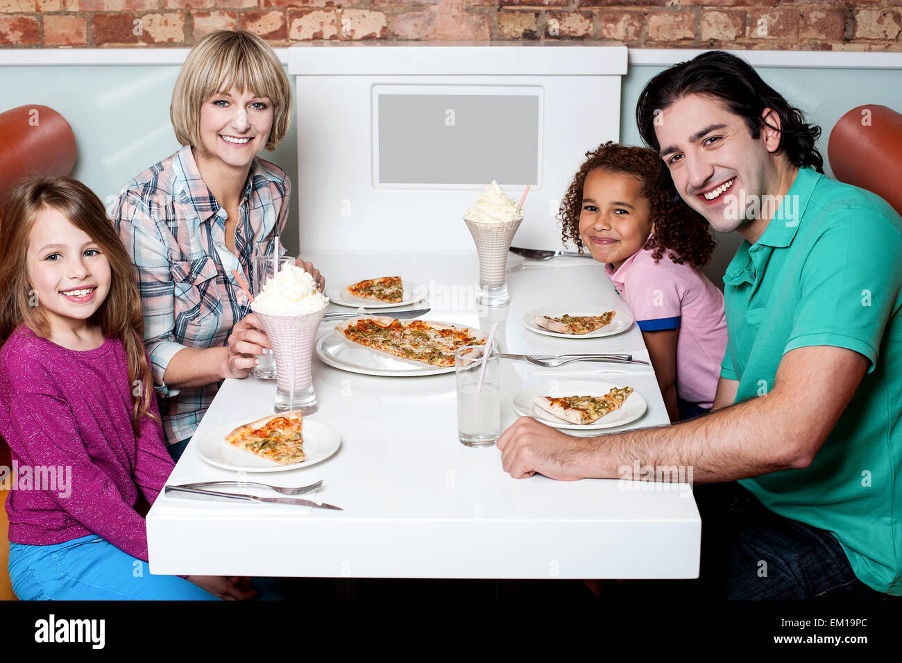 Cheerful family of four enjoying dinner Stock Photo - Alamy