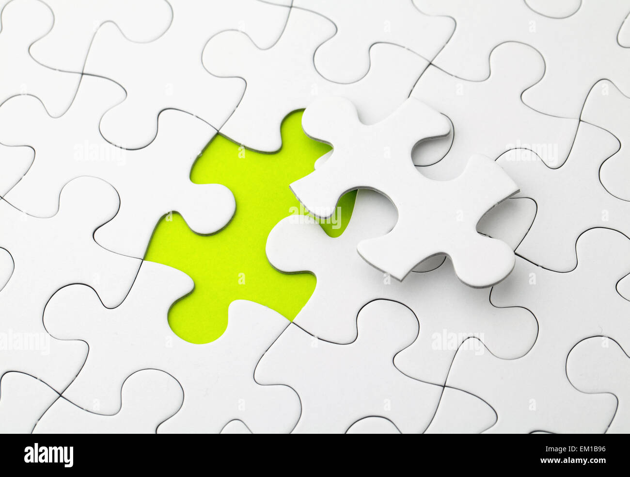 A puzzle is missing two pieces to be completed in different colors. white  pieces and one piece in green and one in orange to add text Stock Photo -  Alamy