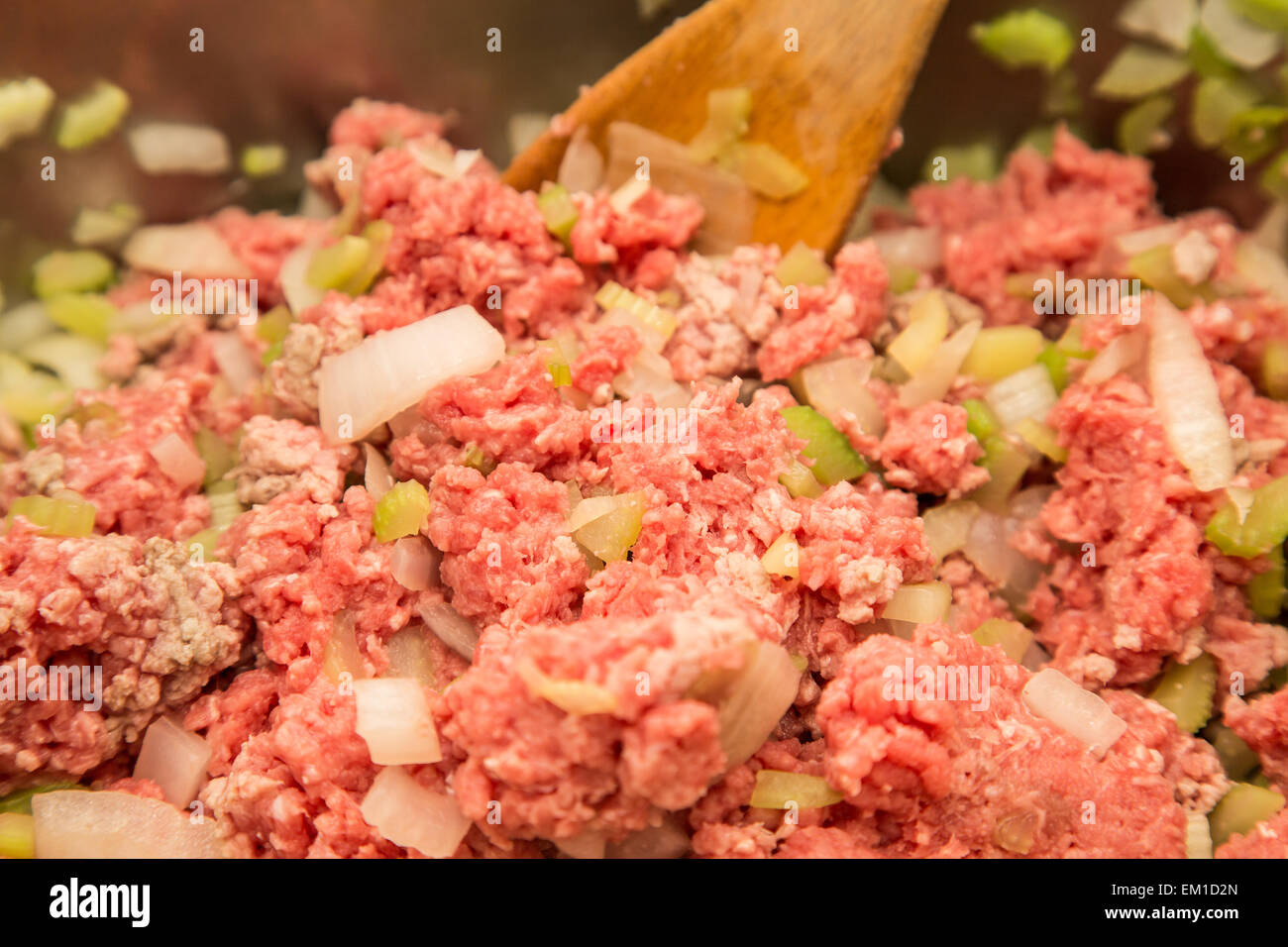 Cooking ground beef, chopped onions and celery in a frying pan with