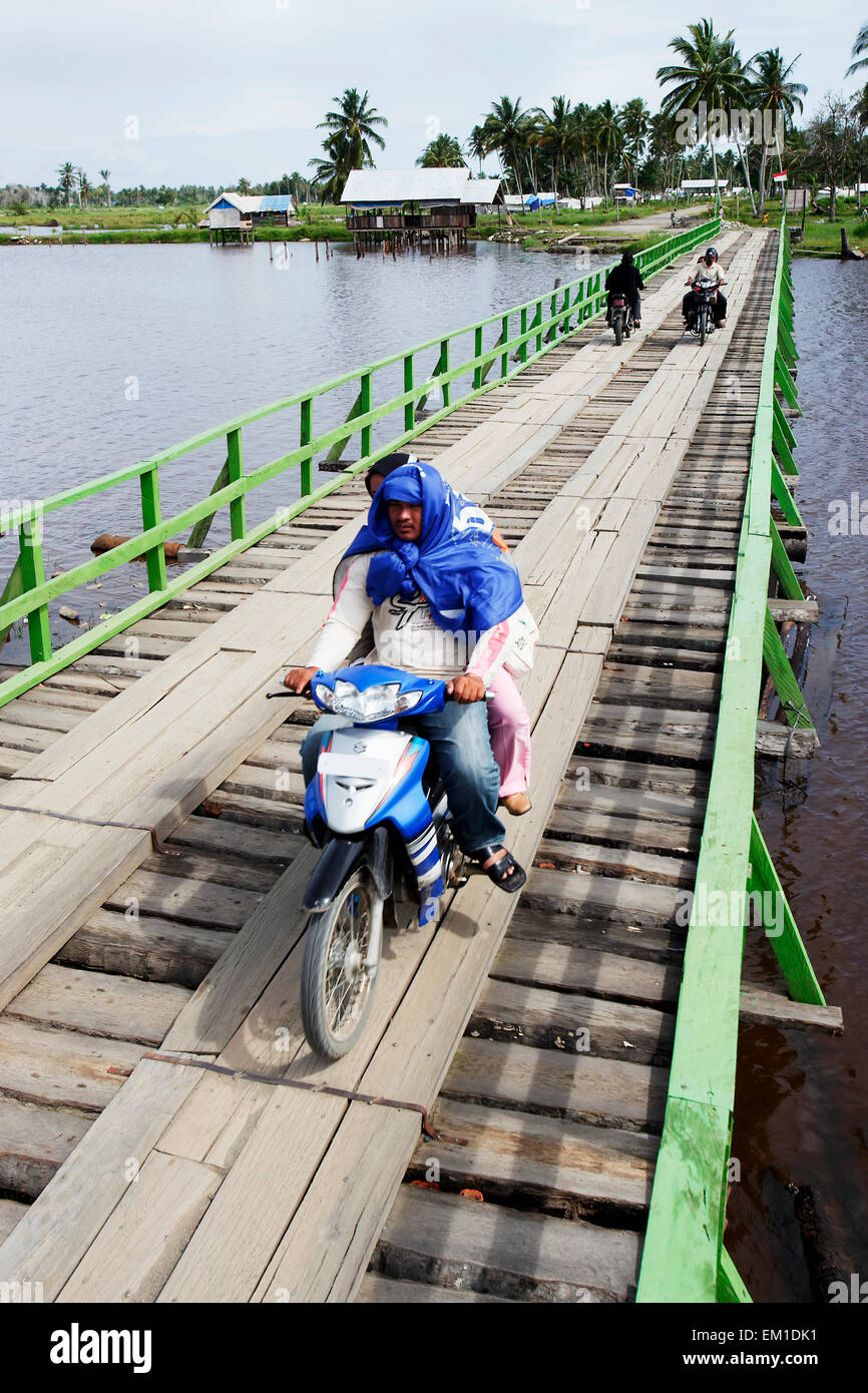 Motorbike crossing a temporary bridge made of wood after the Indian Ocean tsunami in 2004; Sumatra, Indonesia Stock Photo