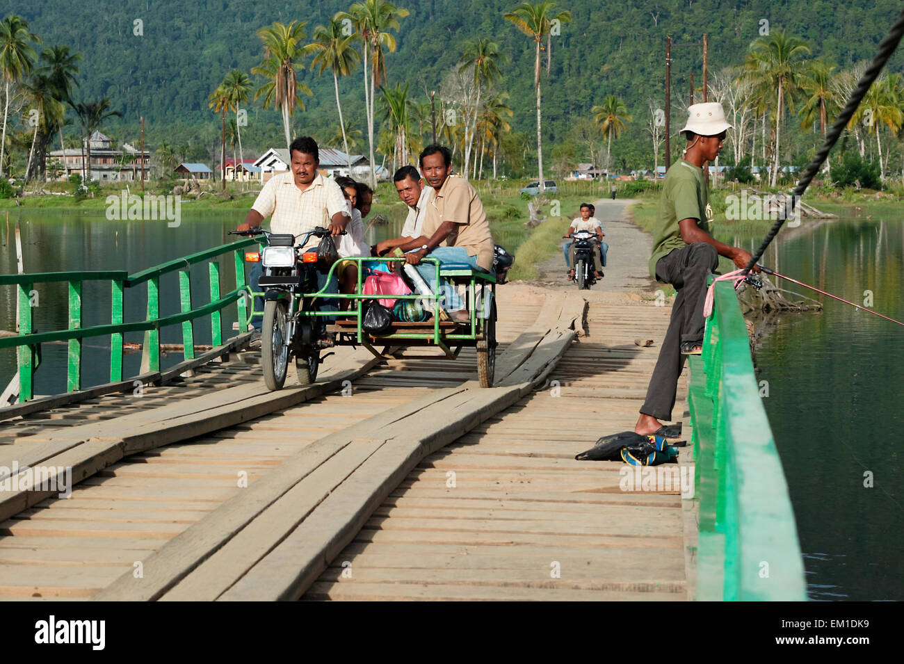 Motorbike with cart crossing a temporary bridge made of wood after the Indian Ocean tsunami in 2004; Sumatra, Indonesia Stock Photo