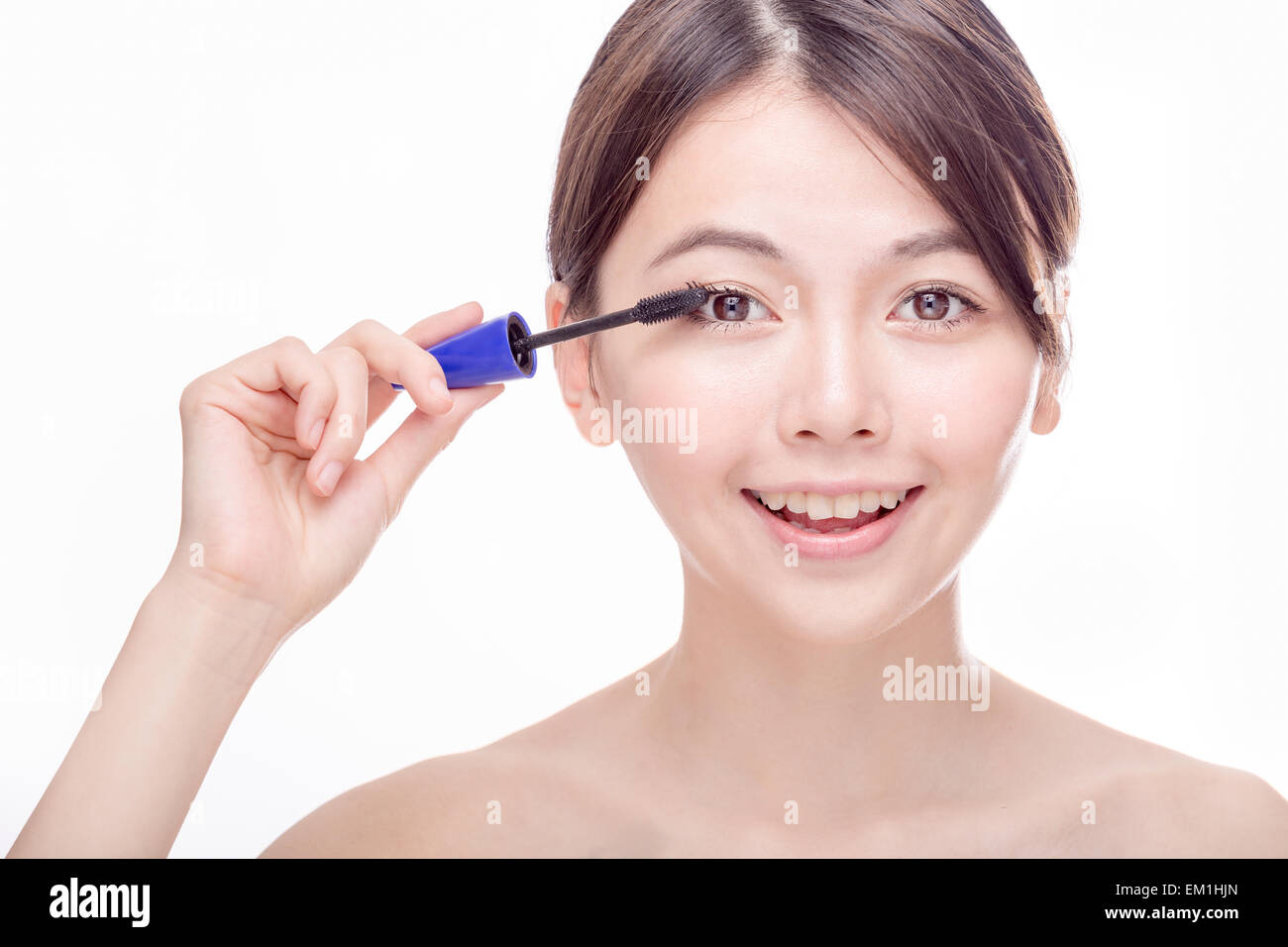 Chinese woman putting mascara on eyelashes Stock Photo