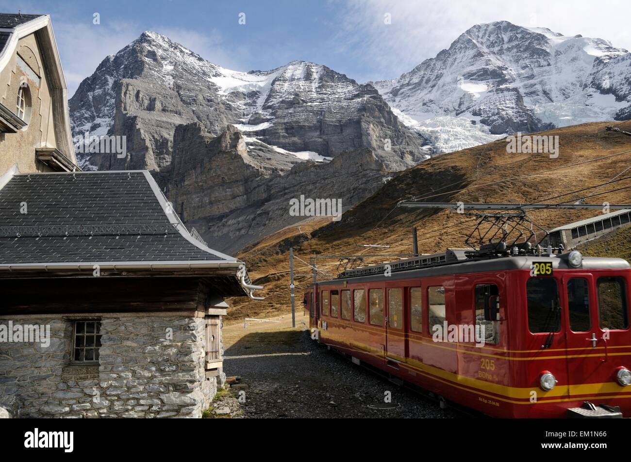Jungfraujoch Railway Train Passing Eiger Information Station with Eiger and Monch in Background Stock Photo