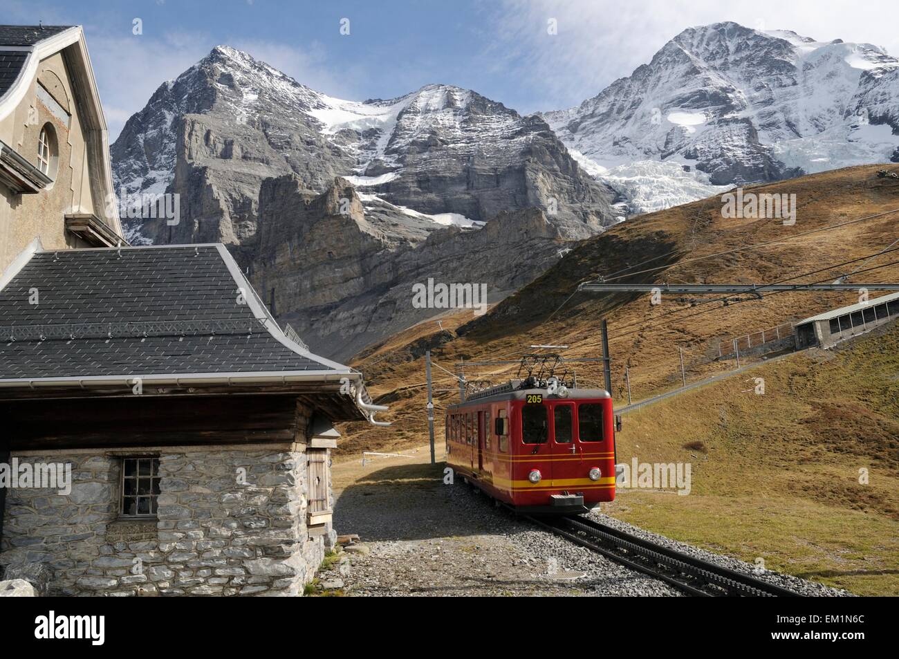 Jungfraujoch Railway Train Passing Eiger Information Station with Eiger and Monch in Background Stock Photo