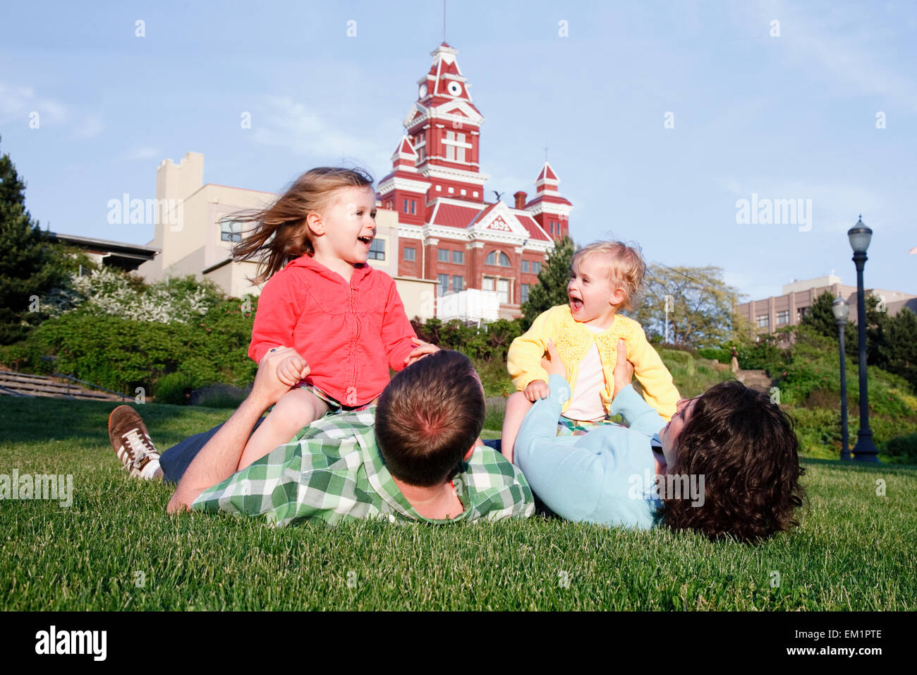 Two Daughters Play With Parents In Grass; Bellingham Washington United States Of America Stock Photo